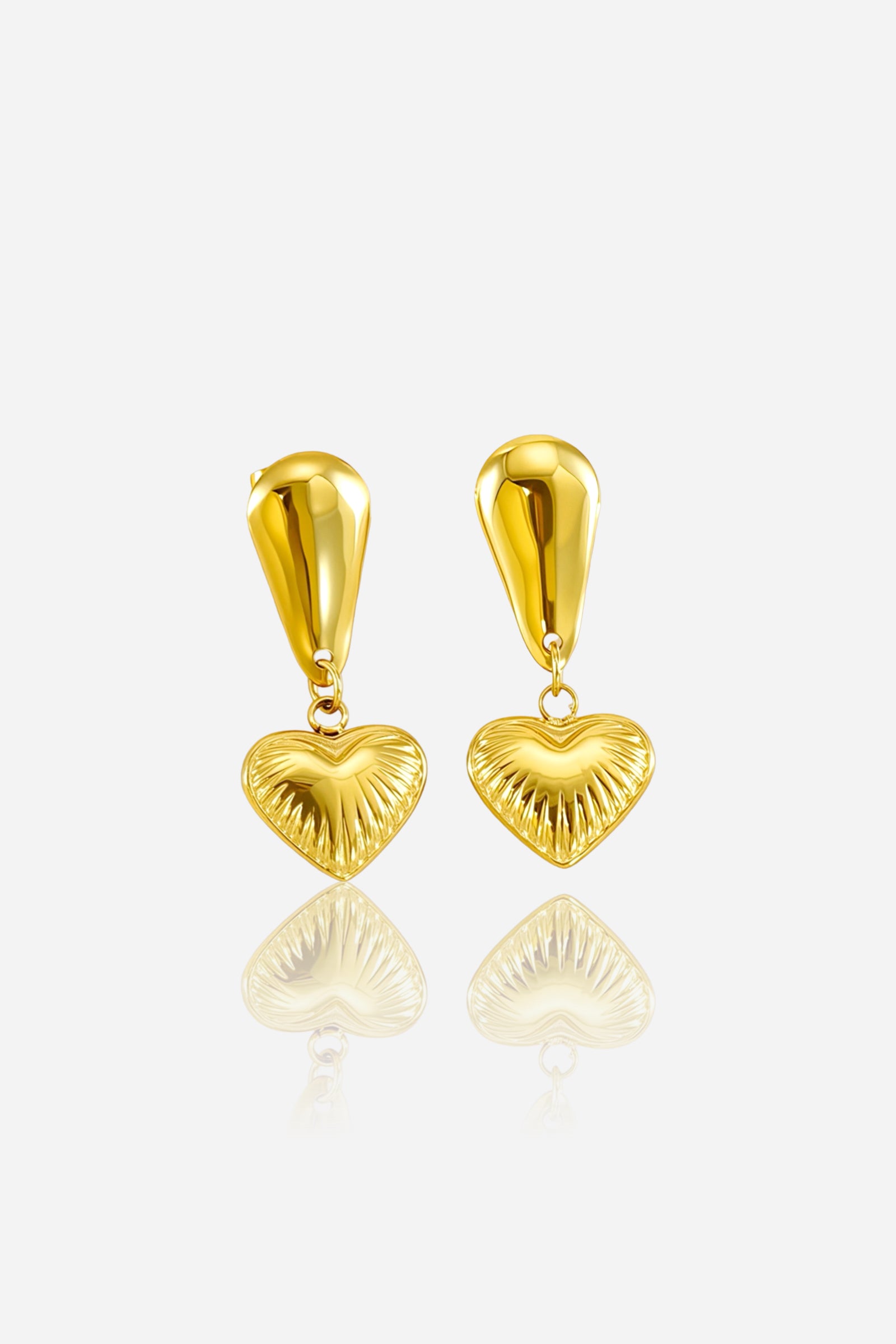Close-up of textured heart drop earrings crafted from stainless steel with a radiant PVD 18K gold-plated finish, featuring an elongated teardrop stud and embossed heart charm – GLISTIA.