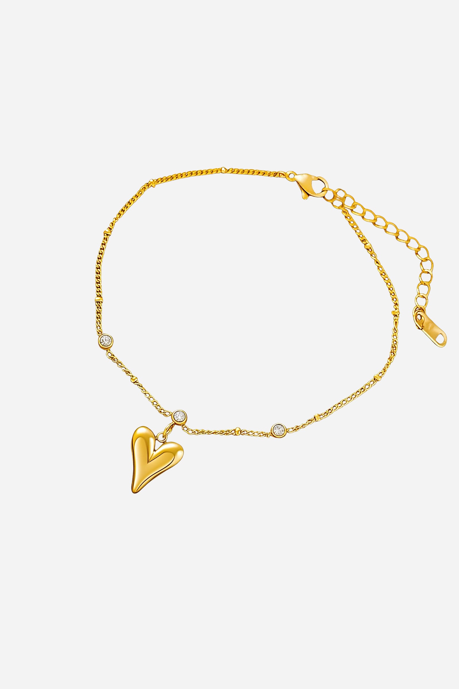 Top view of the gold Amoura anklet featuring a heart charm and bezel-set crystals along the chain – GLISTIA.