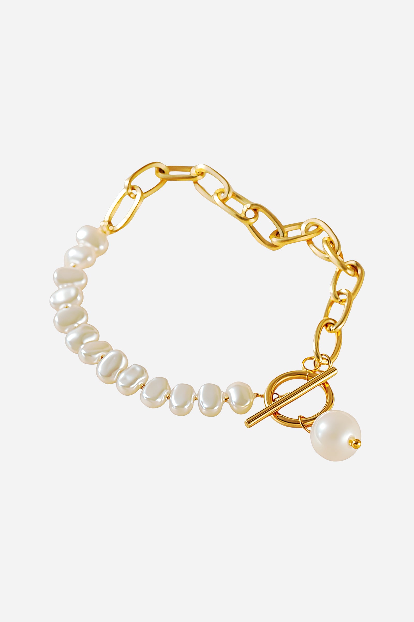 Top-view of GLISTIA’s Aurora bracelet highlighting the contrast of polished gold links and lustrous white pearls with a toggle closure.
