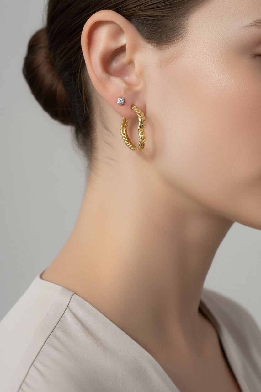 Side view of braided heart-shaped hoop earrings in 18K PVD gold plated stainless steel, polished gold finish by GLISTIA