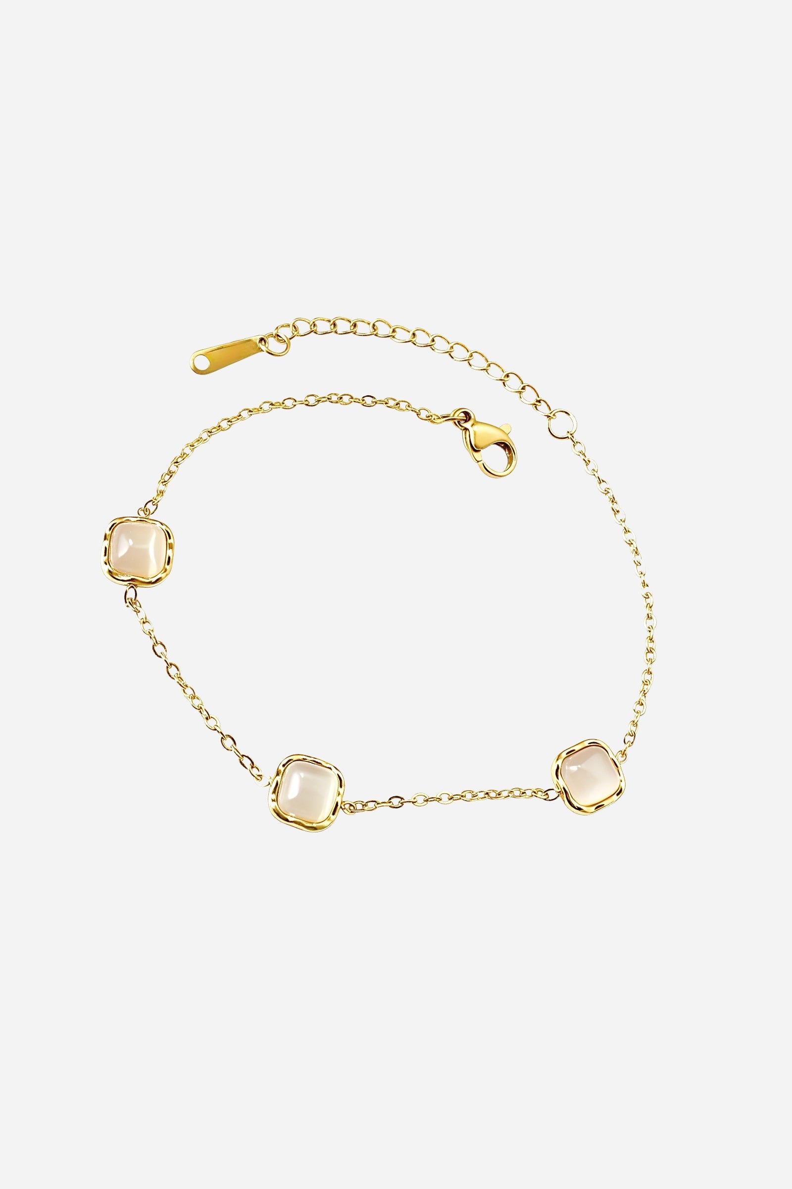 Top-view of GLISTIA’s Celeste bracelet featuring three polished square-cut gems set along a fine gold chain.