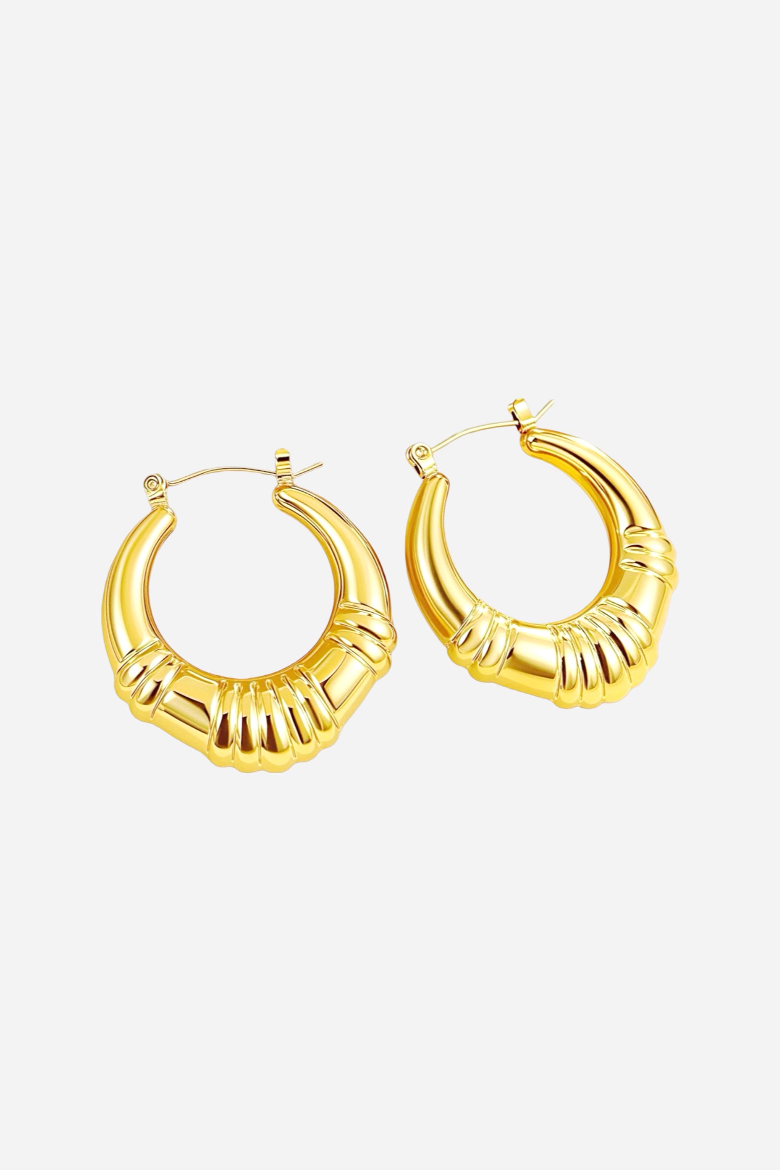 Angled top view of chunky ridged hoop earrings with a sculpted ribbed texture, crafted from stainless steel and finished in a polished PVD 18K gold plating – GLISTIA.