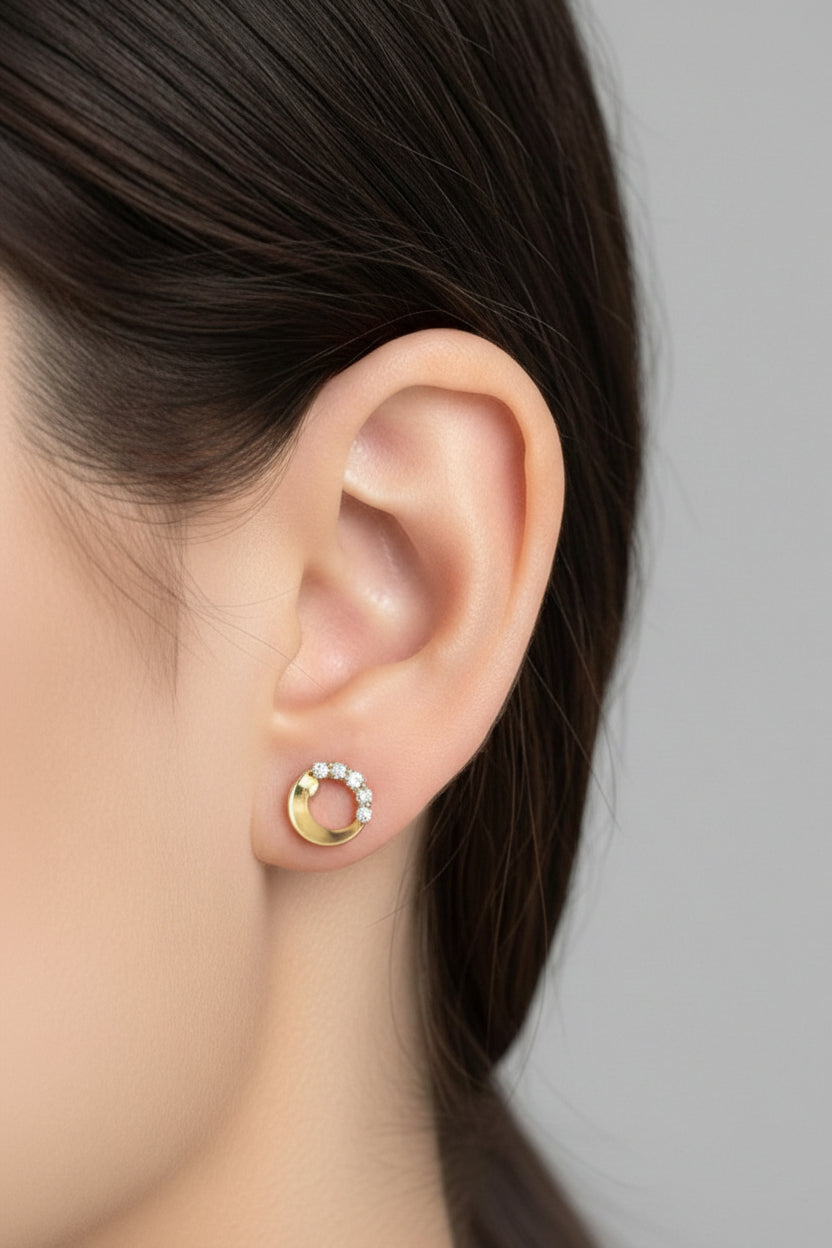 Dainty crescent moon crystal stud earrings in 18K PVD gold plated stainless steel, shown on ear with subtle celestial sparkle