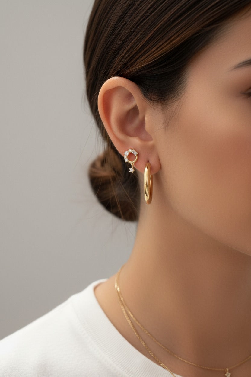 Crystal baguette circle piercing earrings crafted from stainless steel with gold plating, featuring an open circle design set with baguette and round cubic zirconia crystals