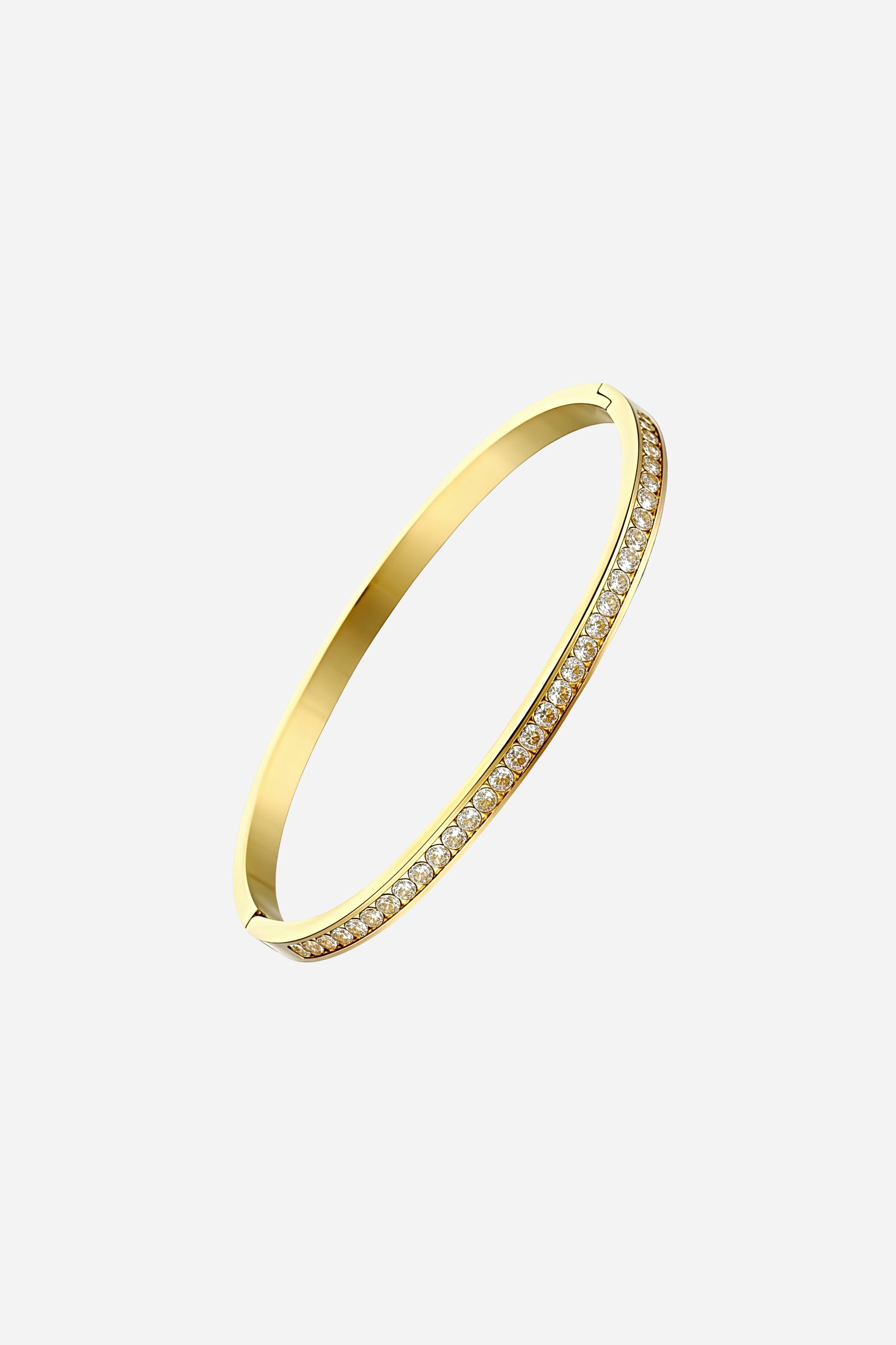 Angled shot showcasing the slim profile, mirror-polished finish, and crystal bar detail of the PVD 18K gold-plated stainless steel bangle – GLISTIA.