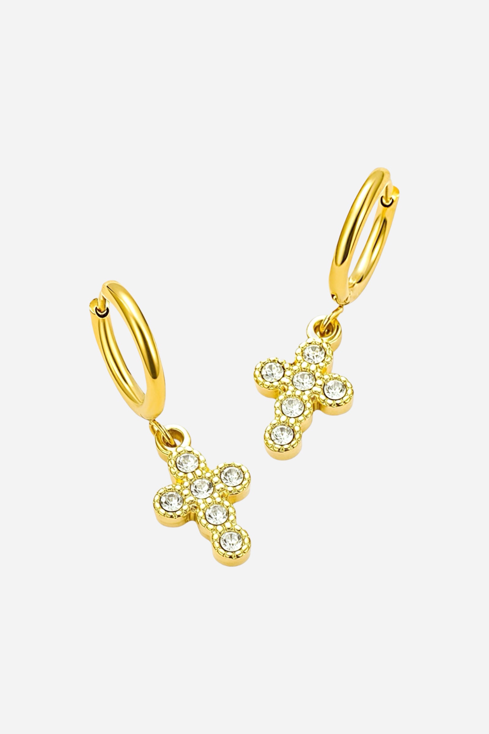 Angled view of crystal cross charm hoop earrings crafted from stainless steel with a radiant PVD 18K gold plated finish, featuring small hoops with sparkling crystal cross pendants - GLISTIA.