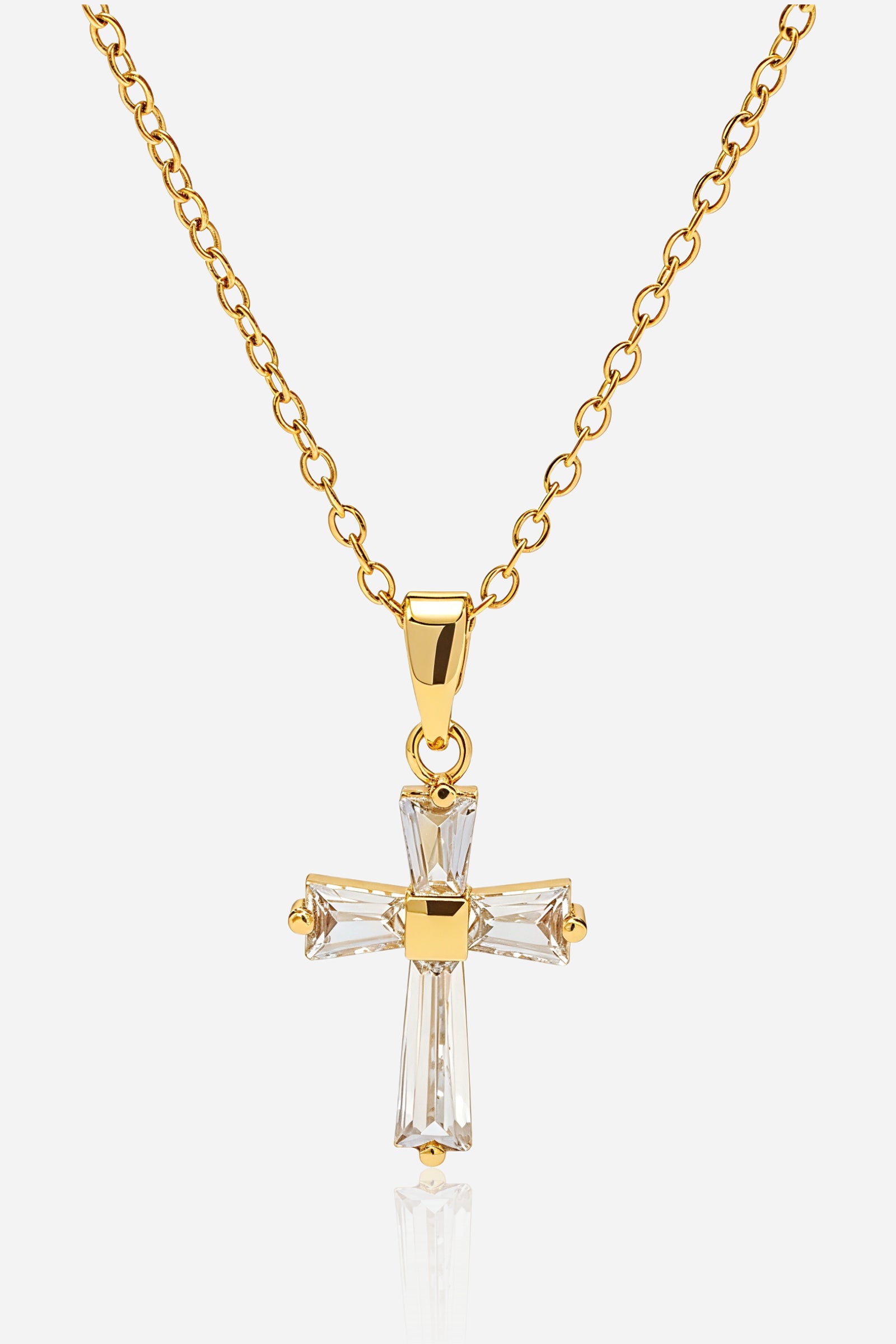 Close-up shot of GLISTIA 18K gold PVD cross pendant with clear zircon baguettes.