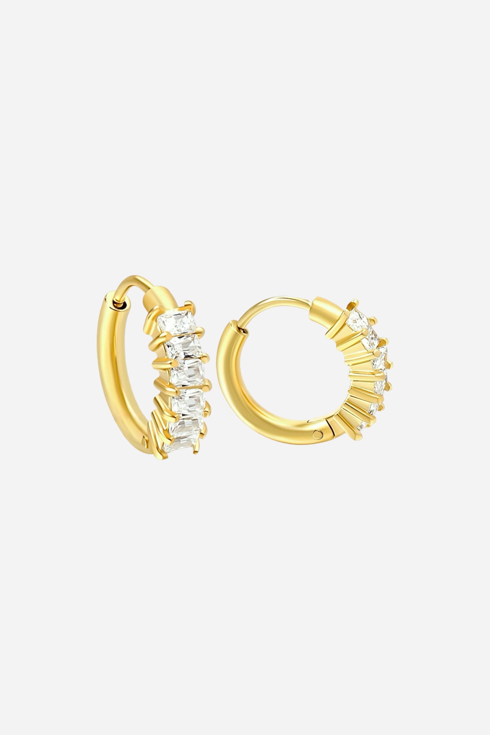 Close-up of small gold hoop earrings crafted from stainless steel with PVD 18K gold plating, featuring prong-set baguette and round cubic zirconia stones for a refined, radiant finish – GLISTIA.