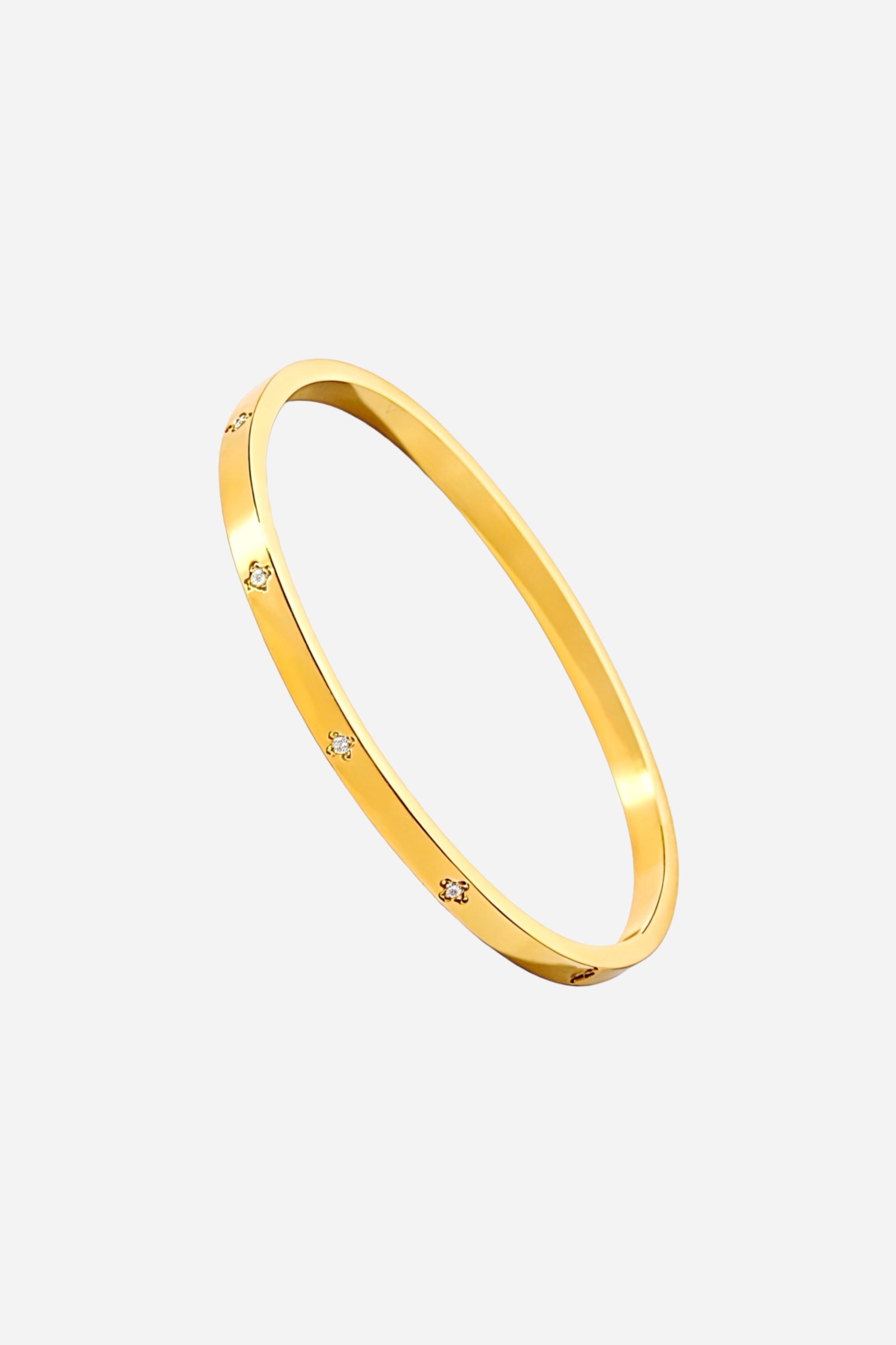 Side angle showing the sleek polished 18K gold plating and delicate cubic zirconia accents on the slim stainless steel bangle – GLISTIA.