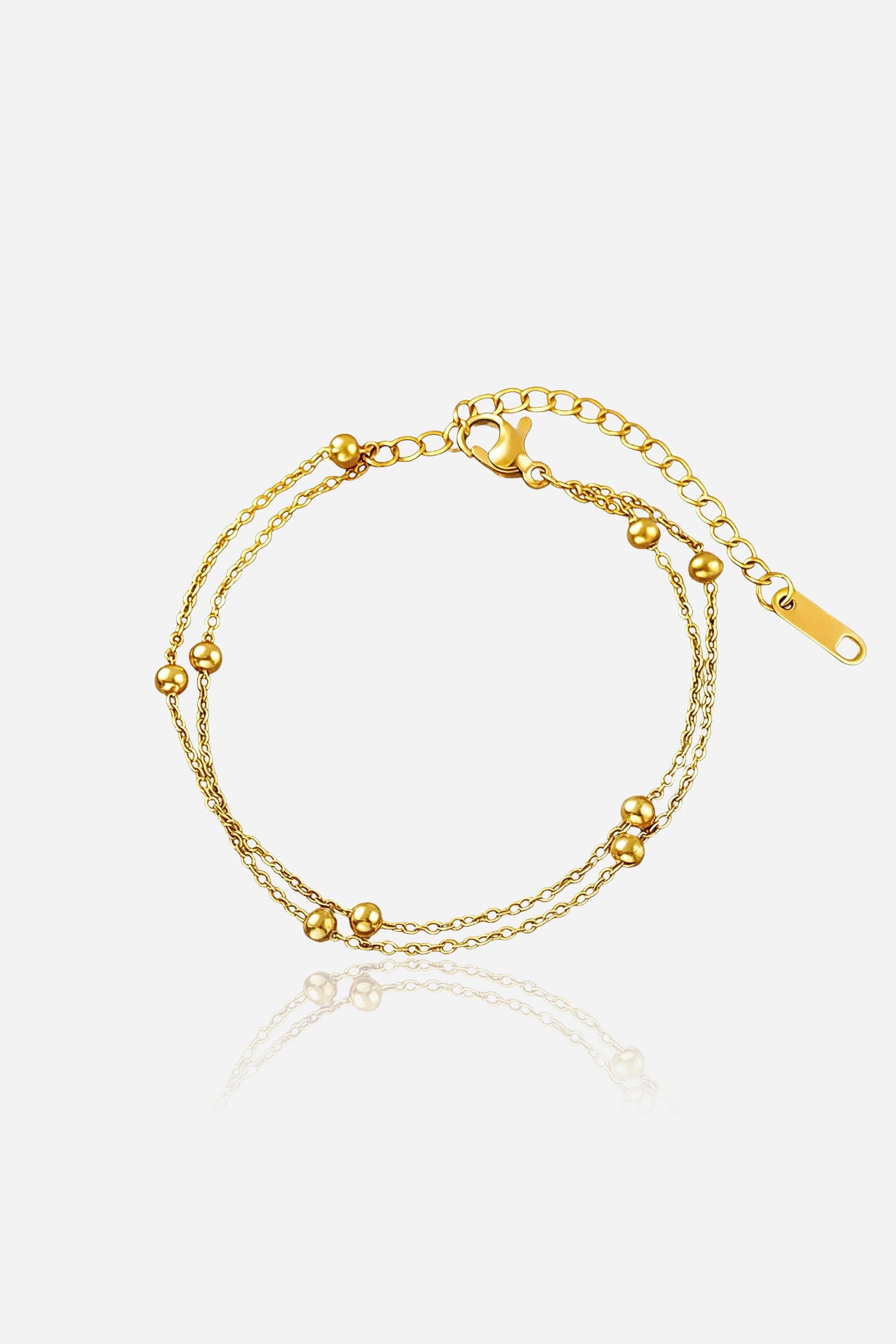 GLISTIA dual chain beaded gold bracelet in PVD 18K gold plated stainless steel shown from the front with smooth bead accents.