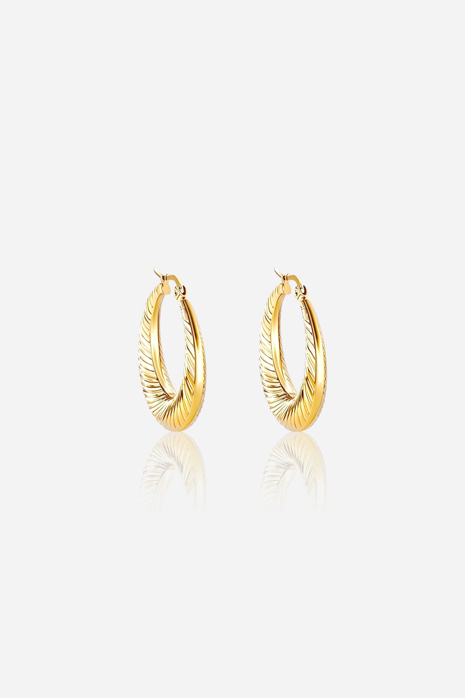 Close-up view of GLISTIA Elara Twist Hoop Earrings crafted from stainless steel and plated with 18K PVD gold, featuring a sculpted twisted design with a reflective polished finish on a light background.