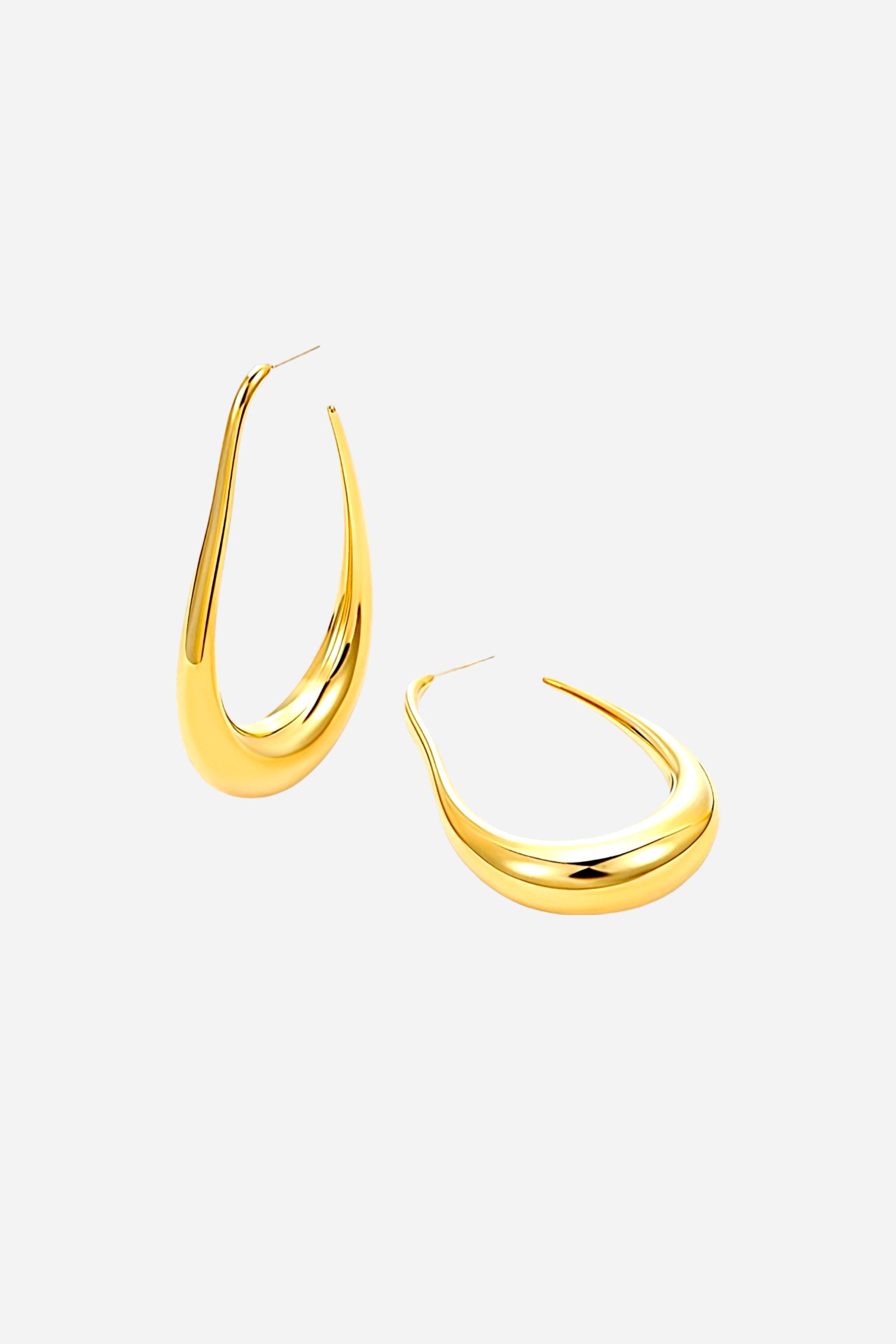 Angled side view of elongated sculptural hoop earrings with a fluid teardrop silhouette, crafted from stainless steel and finished in polished PVD 18K gold plating – GLISTIA.
