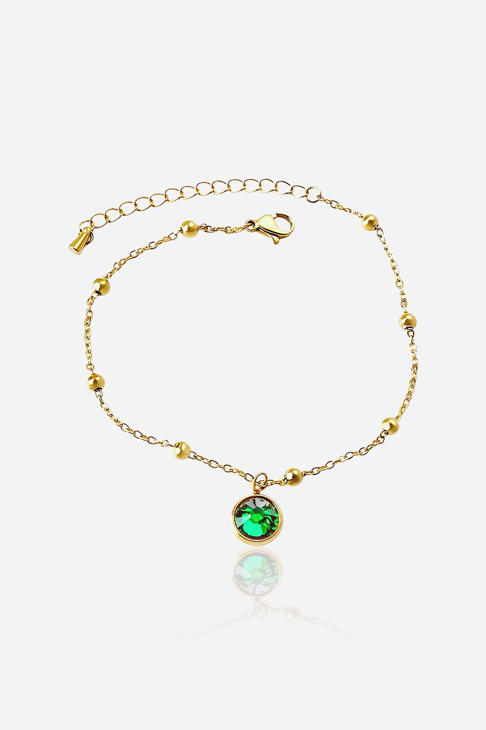 Top view of gold Emerald Glow Beaded Anklet showcasing round beads and a bezel-set emerald green crystal charm - GLISTIA.