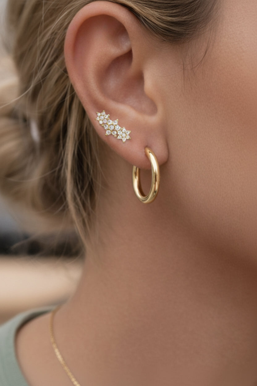 Floral cluster stud earrings crafted from stainless steel with 18K PVD gold plating, featuring flower-shaped cubic zirconia clusters arranged in a soft curved design