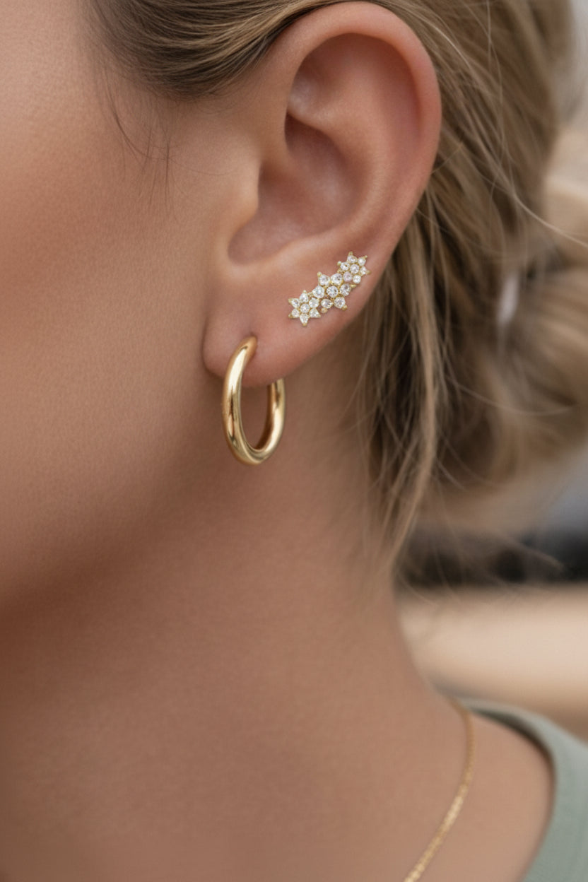 Close-up of floral cluster stud earrings highlighting brilliant-cut cubic zirconia stones set in 18K PVD gold plated stainless steel