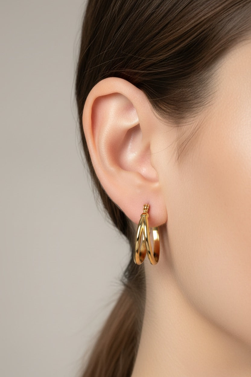 GLISTIA 18K PVD gold plated polished double hoop earrings shown on model from side view.