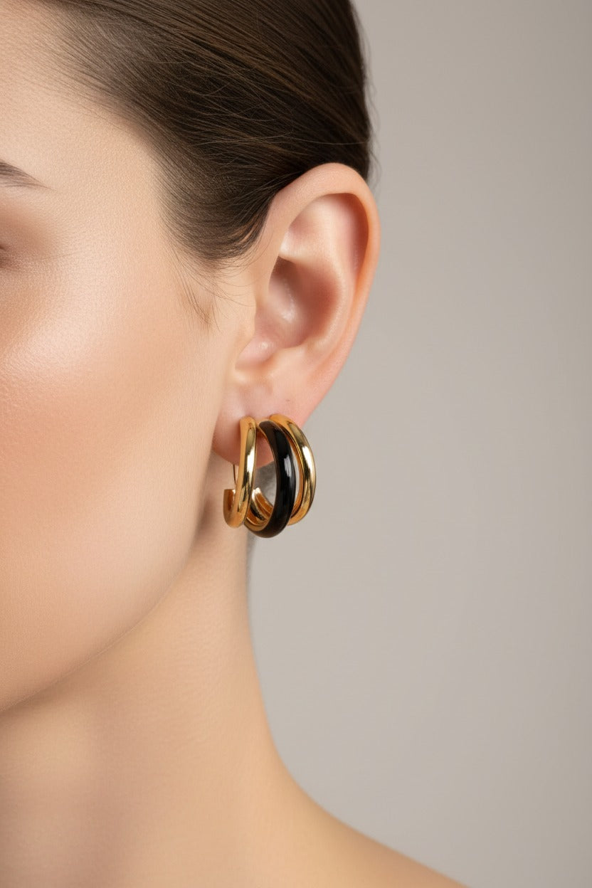 Gold and black double C-hoop earrings crafted from stainless steel with 18K PVD gold plating and glossy black enamel, featuring a layered dual-hoop design
