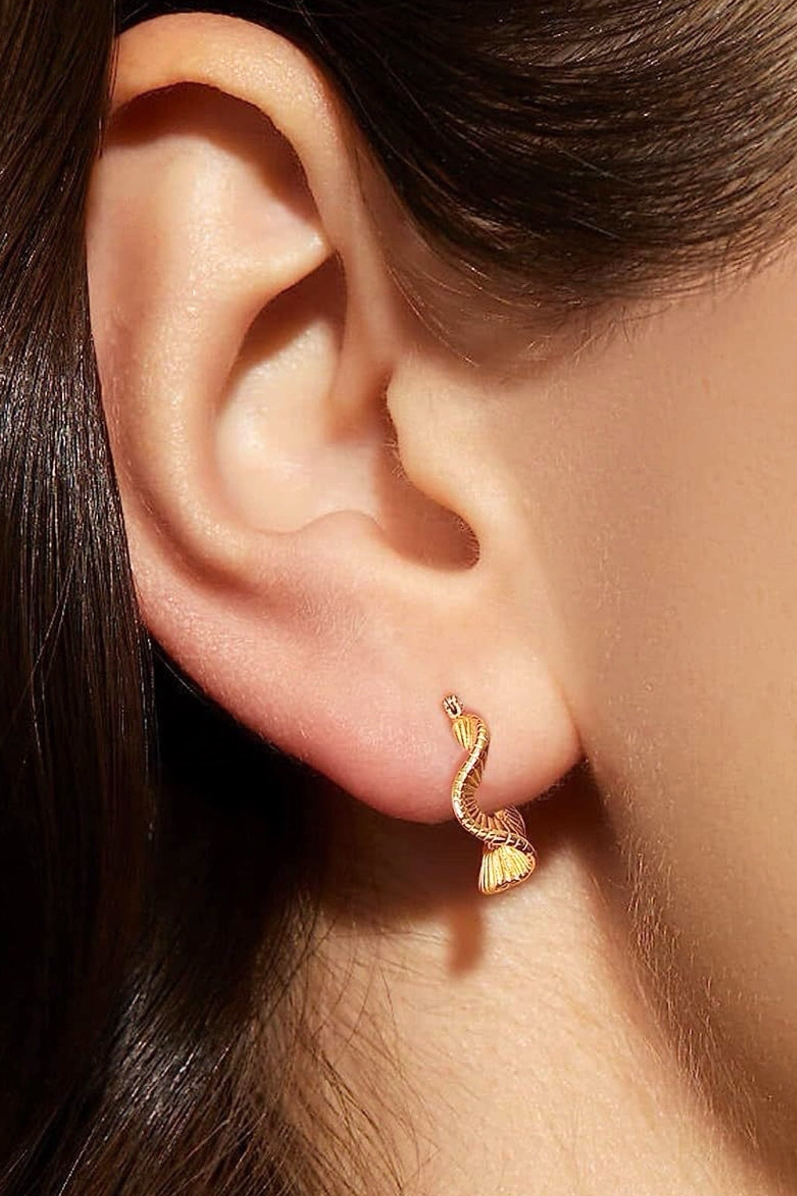 Model wearing 18K gold plated geometric ripple hoop earrings made from stainless steel, showcasing elegant sculpted wavy design – GLISTIA jewellery