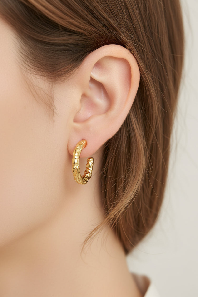 Gold molten textured hoop earrings crafted from stainless steel with 18K PVD gold plating, featuring an organic sculpted surface and polished finish