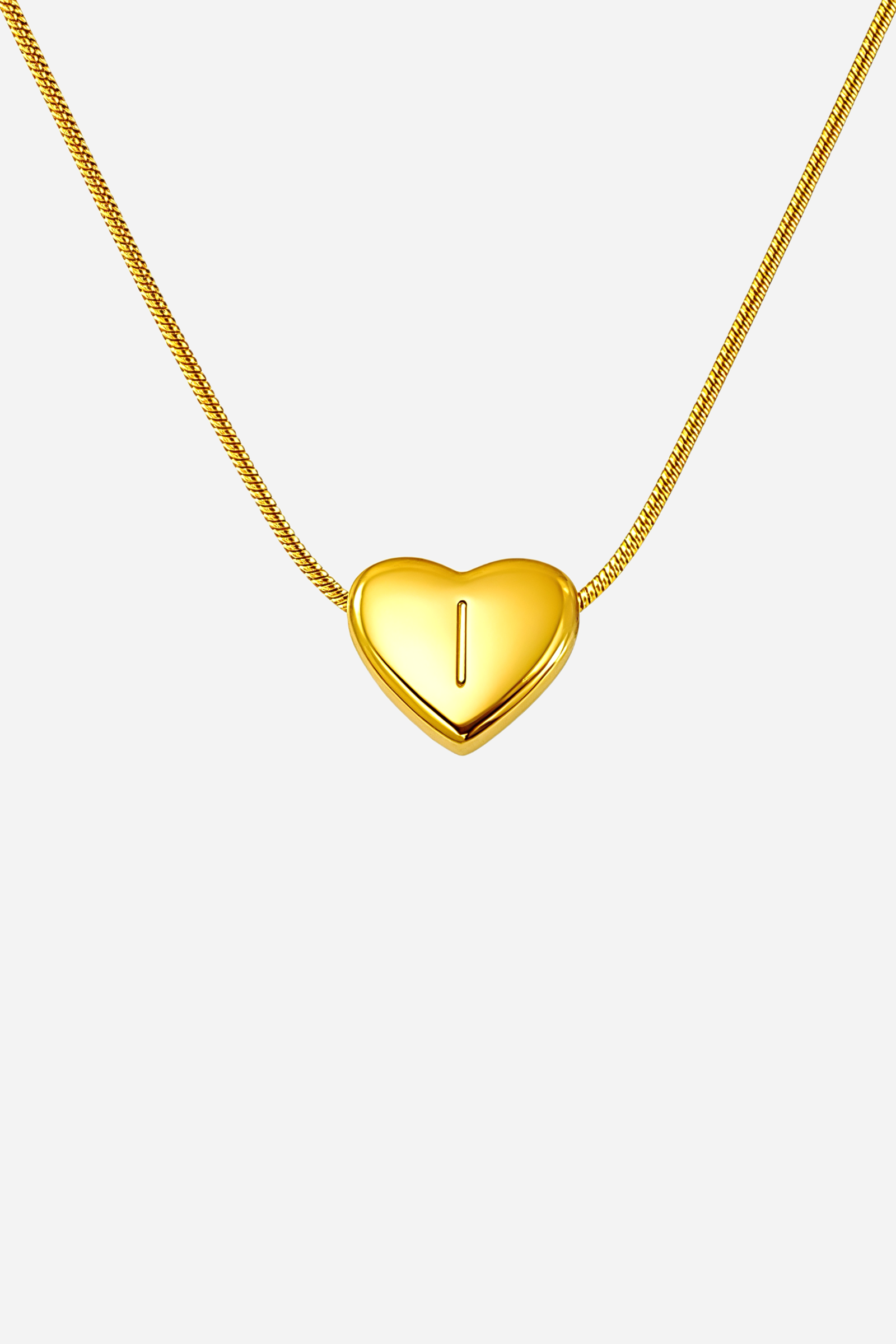 Close-up of heart-shaped initial ‘I’ pendant highlighting engraved letter and mirror-polished gold finish – GLISTIA