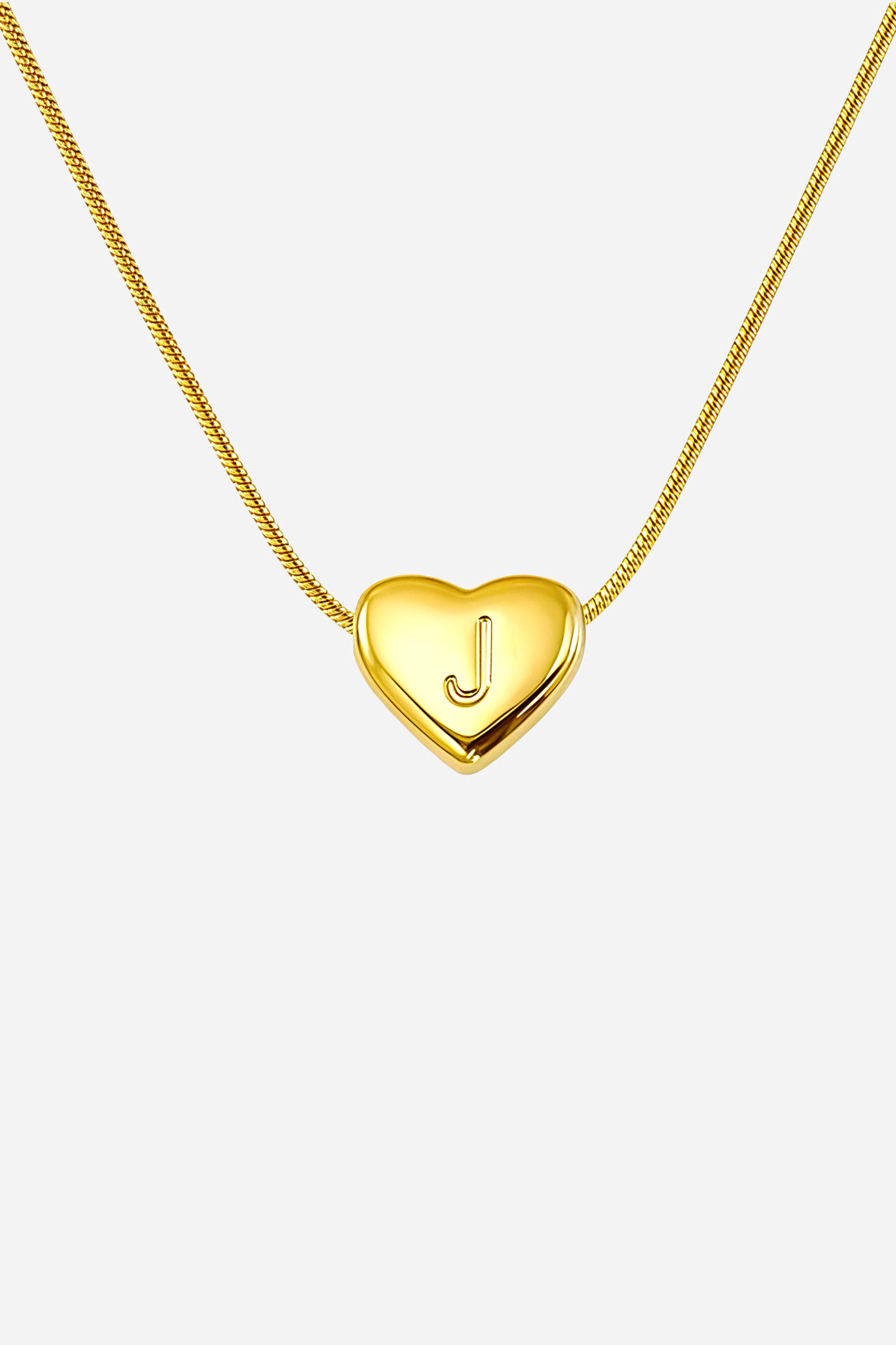 Close-up of heart-shaped initial ‘J’ pendant highlighting engraved letter and mirror-polished gold finish – GLISTIA