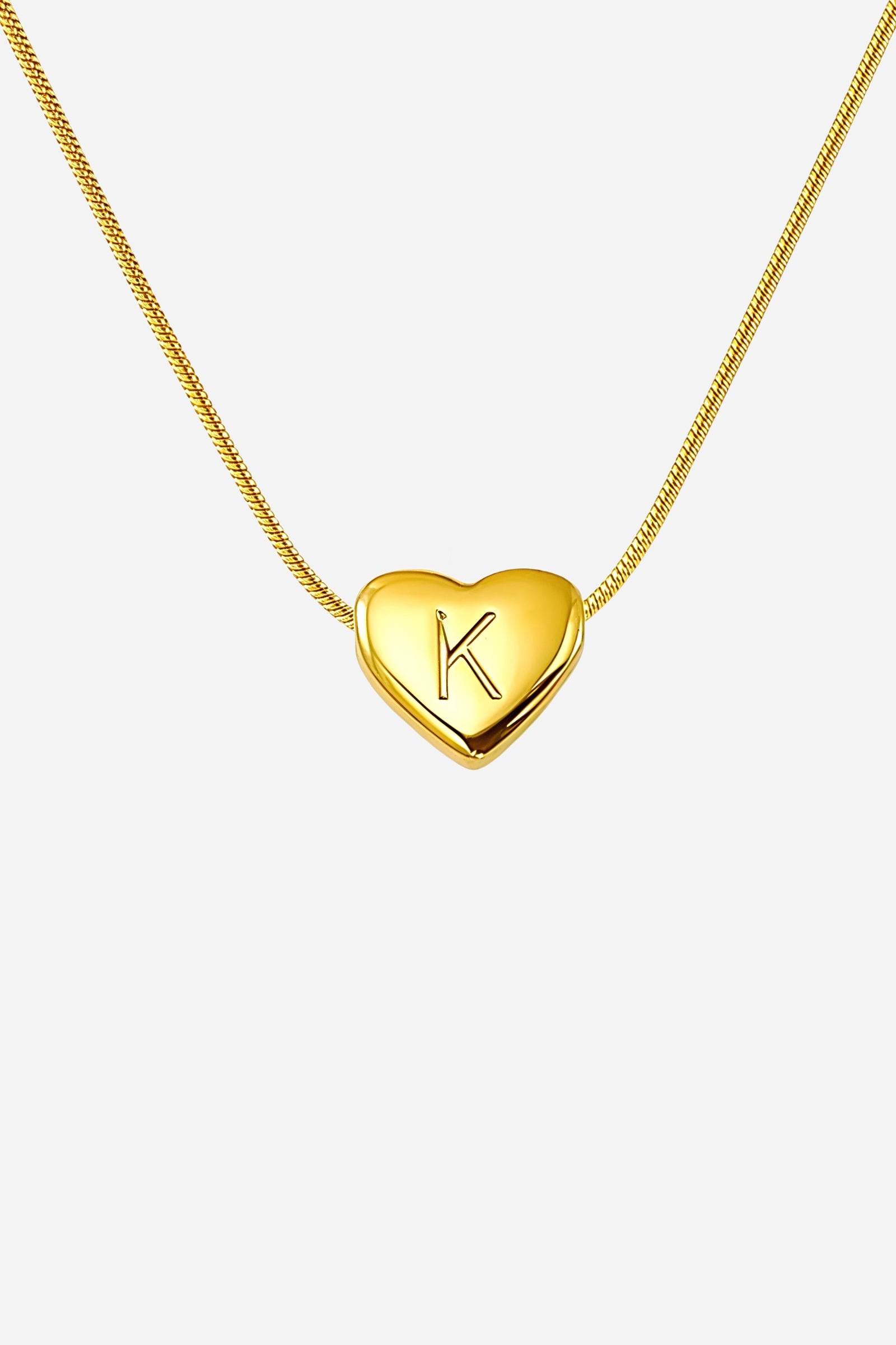 Close-up of heart-shaped initial ‘K’ pendant highlighting engraved letter and mirror-polished gold finish – GLISTIA