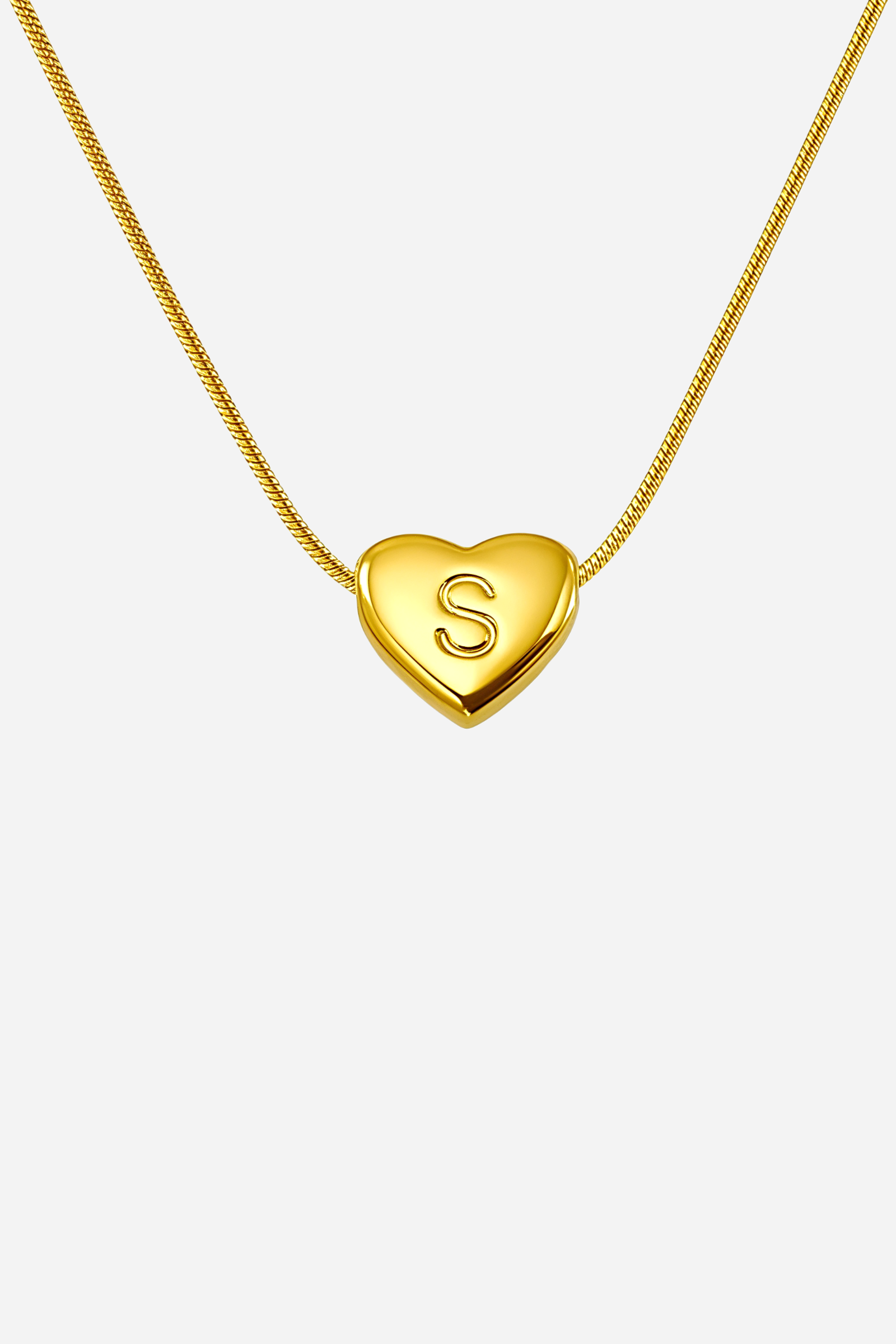 Close-up of heart-shaped initial ‘S’ pendant highlighting engraved letter and mirror-polished gold finish – GLISTIA