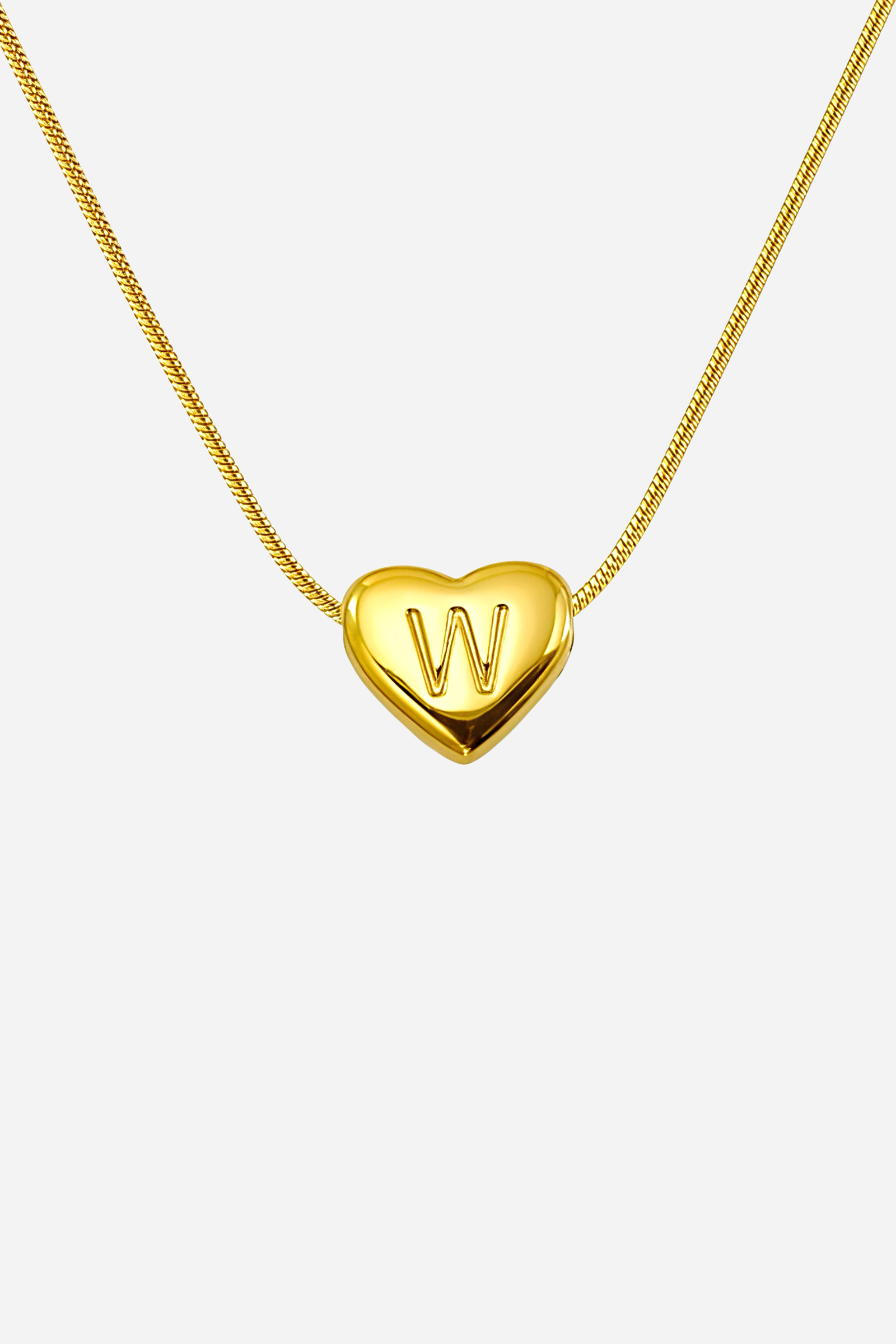 Close-up of heart-shaped initial ‘W’ pendant highlighting engraved letter and mirror-polished gold finish – GLISTIA