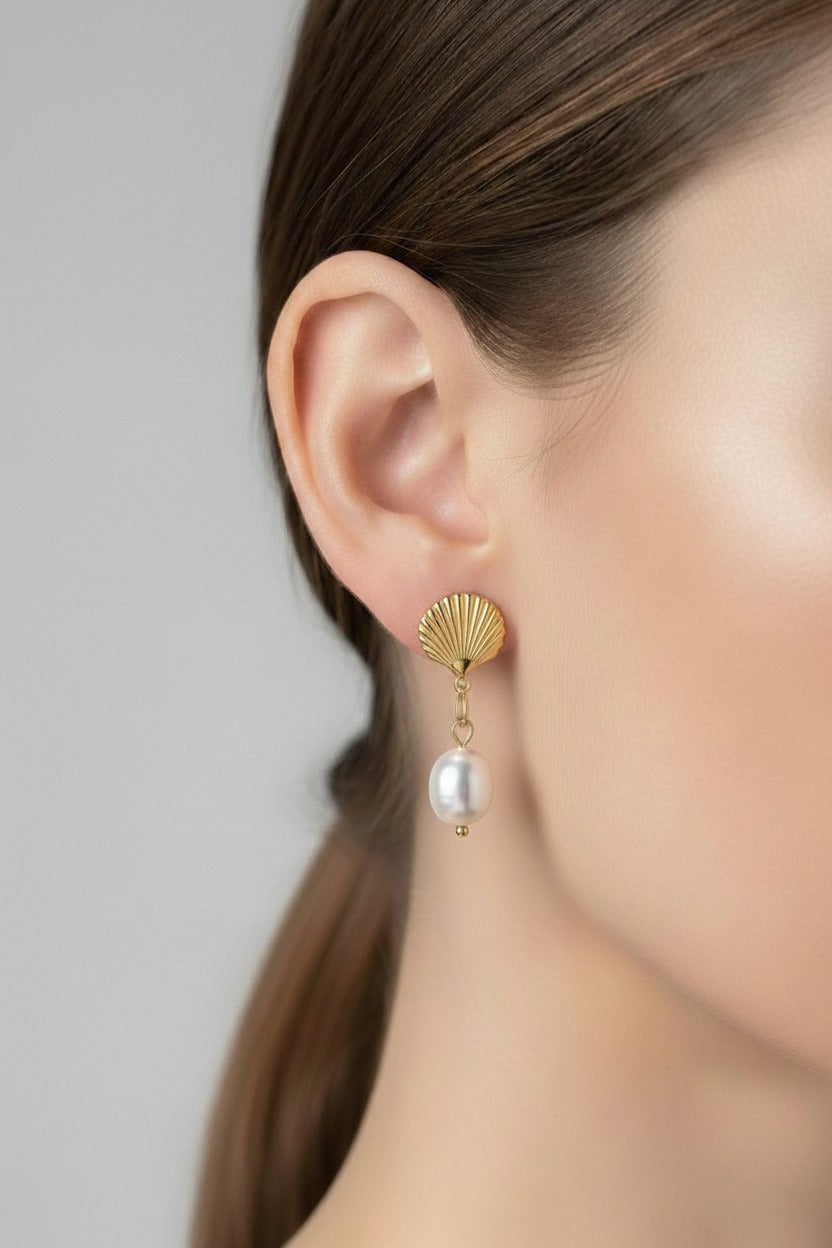 Gold shell pearl drop earrings crafted from stainless steel with 18K PVD gold plating, featuring a polished shell design and dangling pearl.