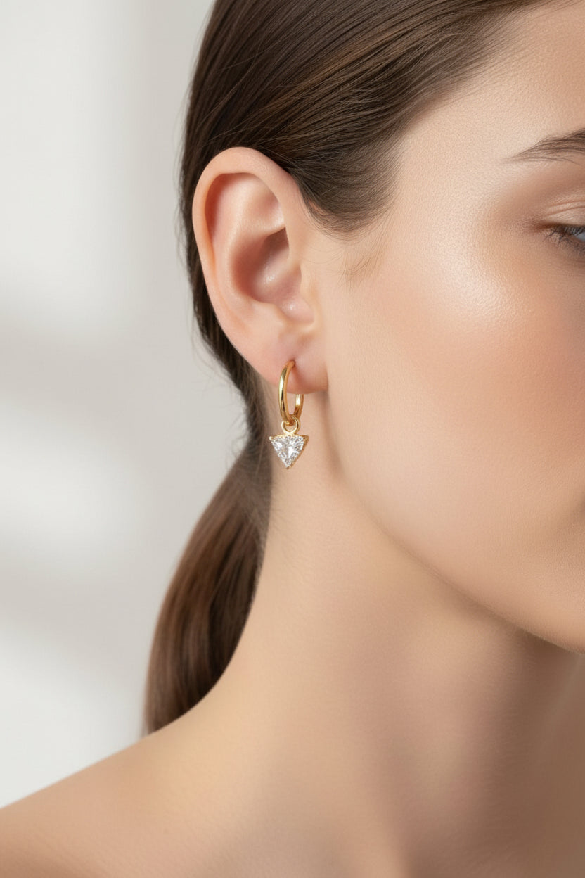 Gold triangle crystal drop hoop earrings crafted from stainless steel with 18K PVD gold plating, featuring a suspended triangular-cut crystal and polished finish