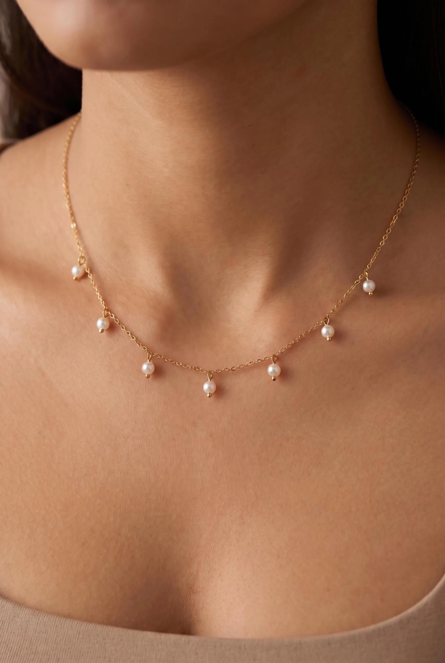 Golden Droplet Pearl Necklace with delicate pearl drops on a gold chain, styled for elegant everyday wear by GLISTIA.