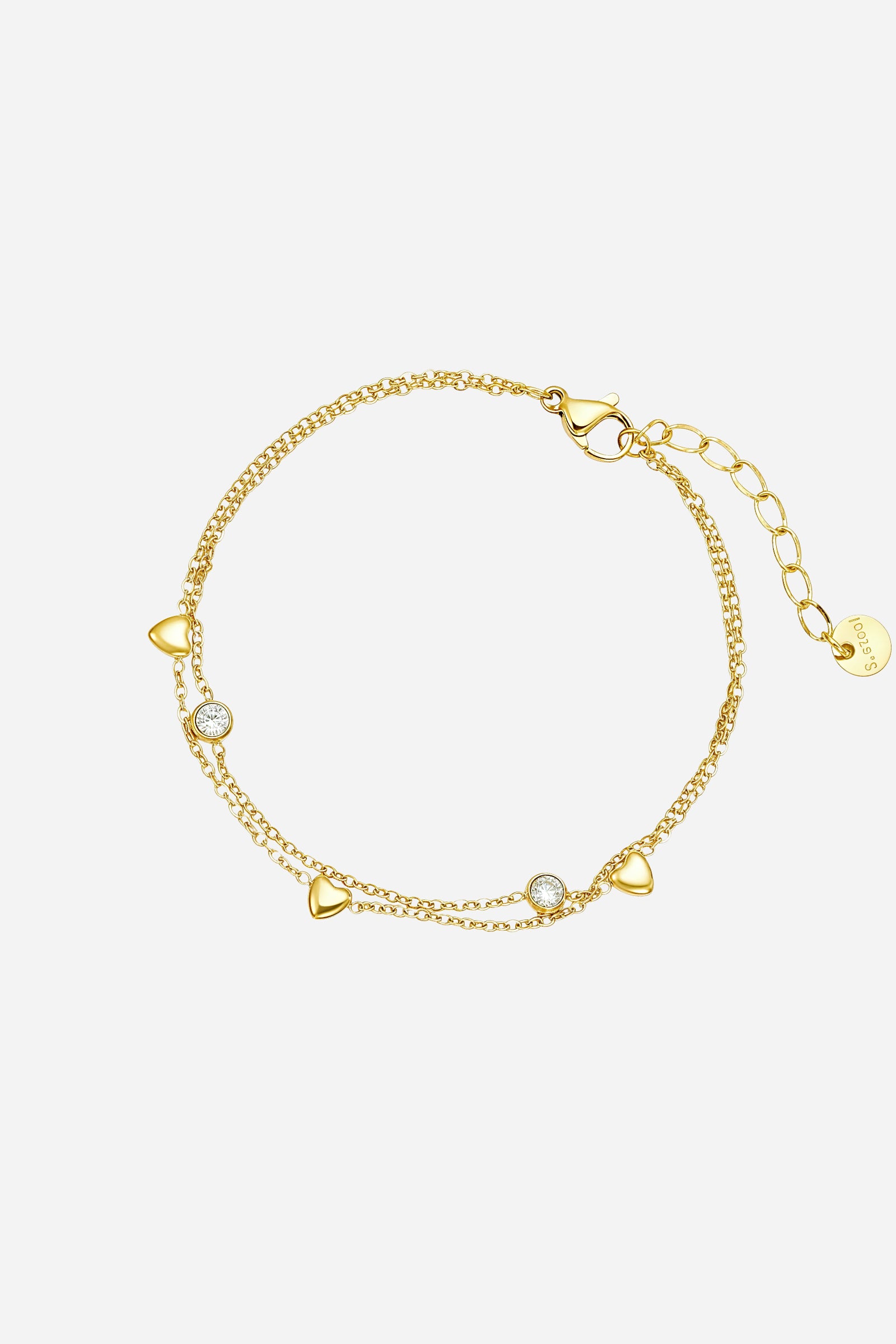 Top-view of GLISTIA’s dual chain bracelet featuring gold heart charms and bezel-set clear crystal accents.