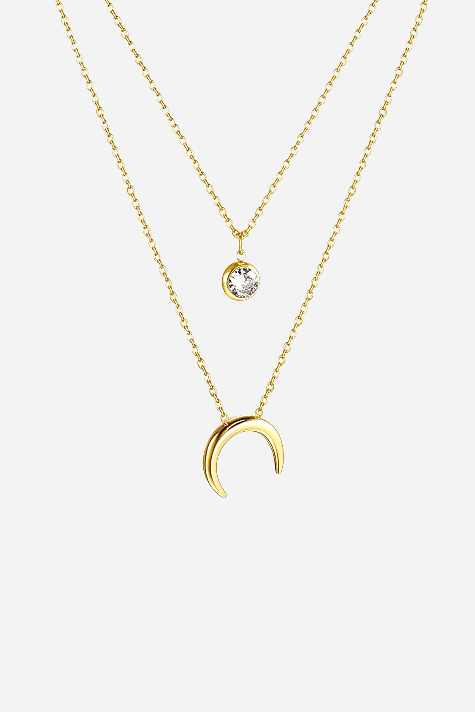 Top-view image of GLISTIA gold layered necklace featuring crescent pendant.