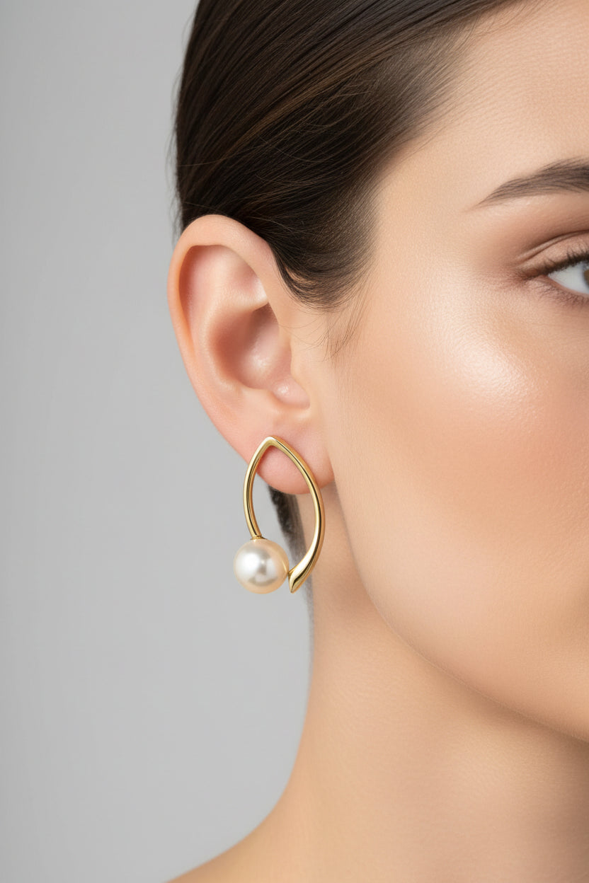Modern marquise pearl earrings worn on ear in 18K PVD gold plated stainless steel