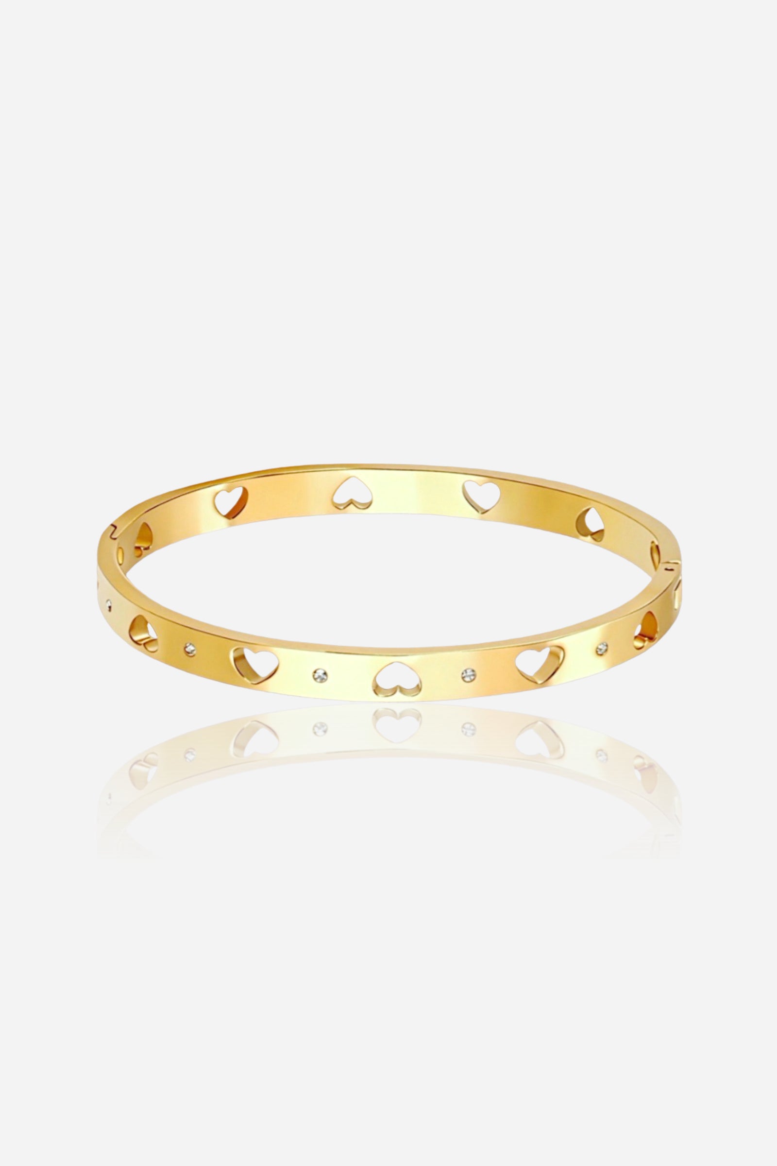 Front view of GLISTIA open heart cut-out bangle crafted from stainless steel with PVD 18K gold plating, featuring symmetrical heart cutouts and delicate crystal accents on a polished surface.