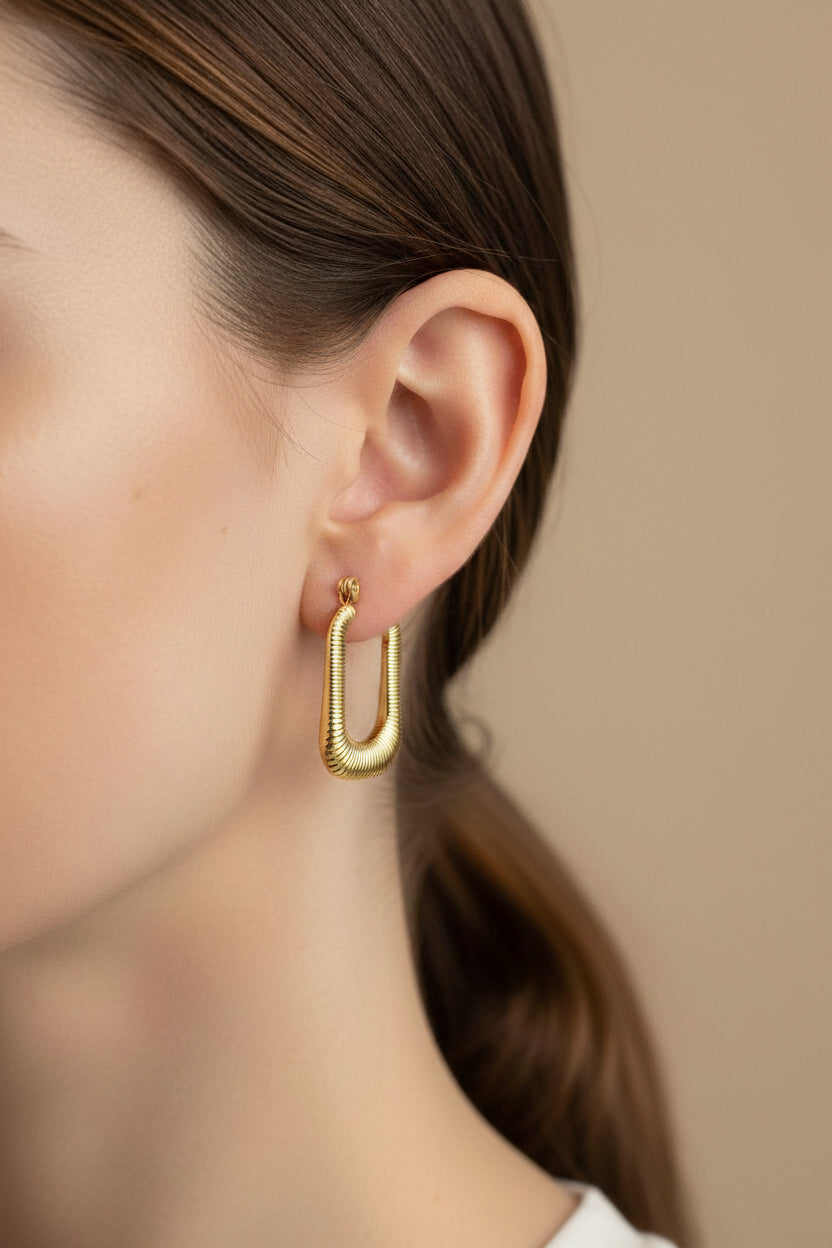 Ribbed rectangle hoop earrings in 18K PVD gold plated stainless steel worn on ear, modern geometric gold hoops by GLISTIA