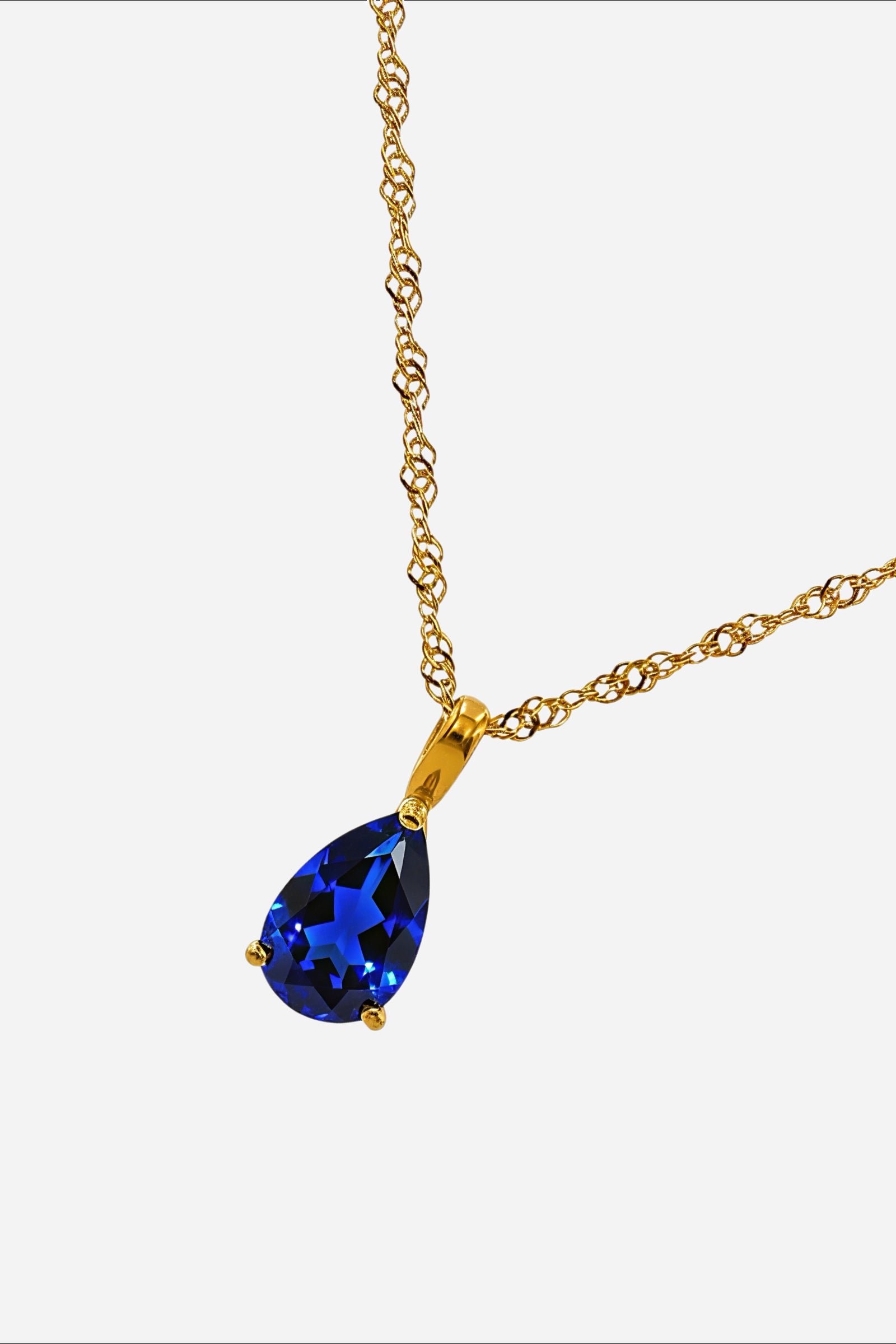 Close-up of Sapphire Blue Zircon pendant with gold-plated setting, September Birthstone Necklace – GLISTIA