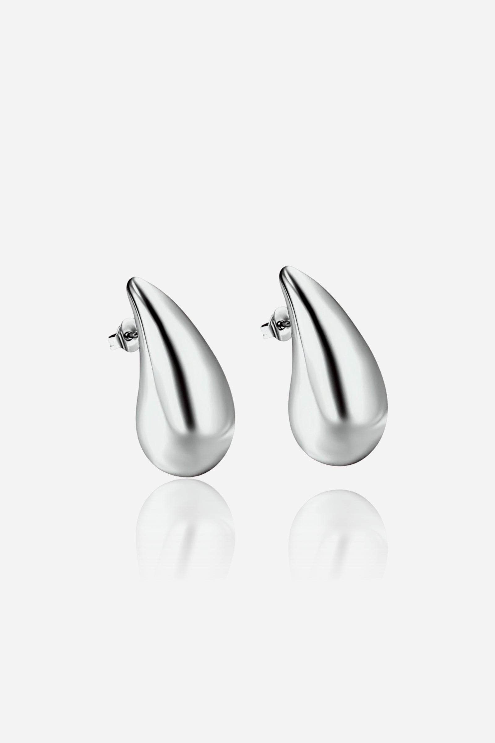 Pair of GLISTIA silver teardrop stud earrings crafted from polished stainless steel, featuring a smooth curved surface with a modern minimalist design on a white background