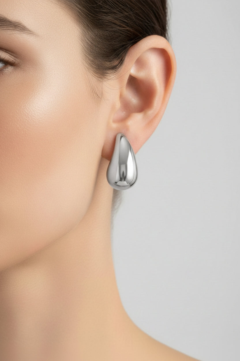 Silver teardrop stud earrings crafted from stainless steel, featuring a smooth polished sculptural teardrop design