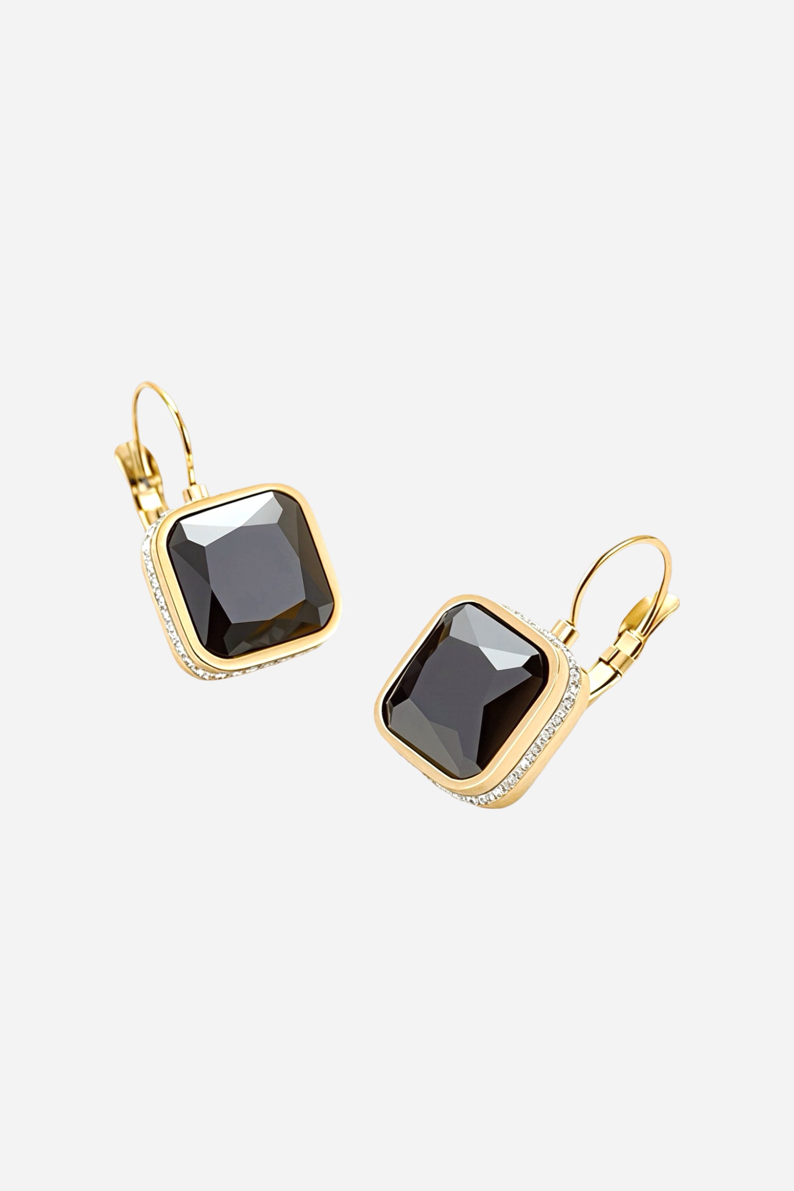 Angled view of square black crystal drop earrings crafted from stainless steel with a lustrous PVD 18K gold plated finish, showcasing faceted dark crystals and lever-back closures - GLISTIA.