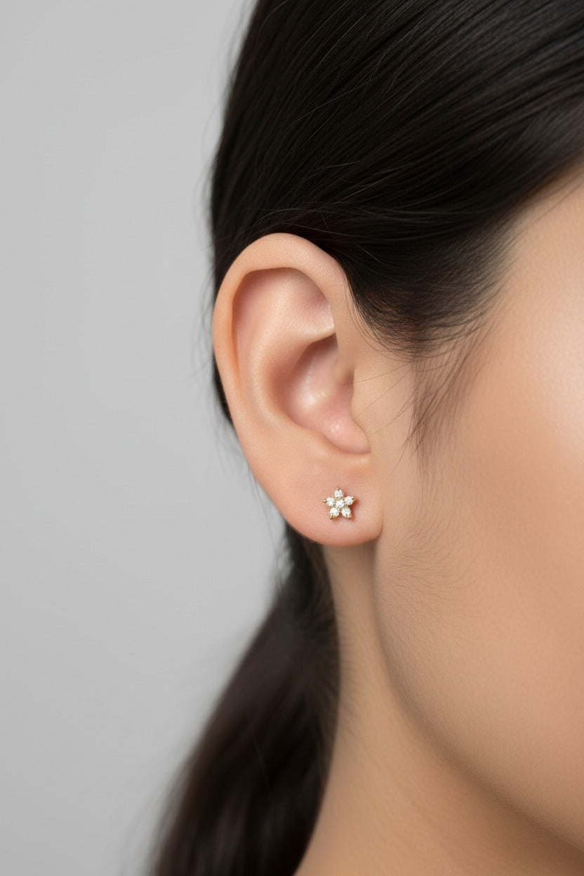 Star crystal flat-back piercing earring in stainless steel with 18K PVD gold plating styled in a clean minimal flat lay