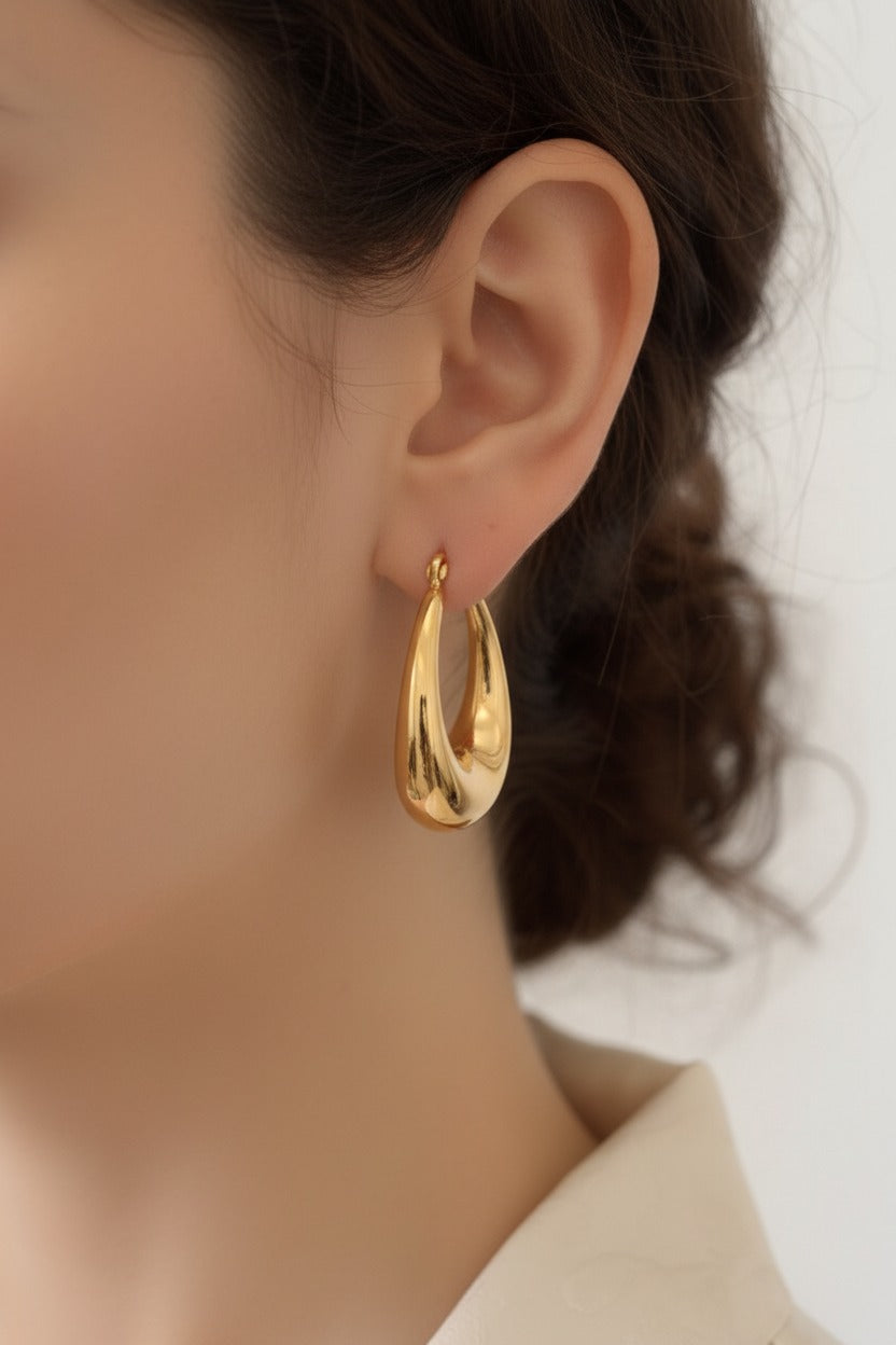 Close-up view of teardrop hoop earrings crafted from stainless steel with 18K PVD gold plating and a smooth mirror finish.