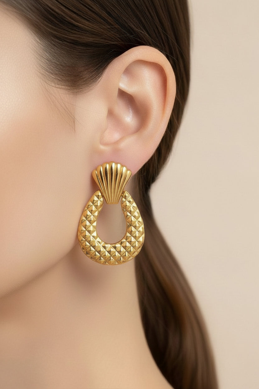 Close-up detail of textured drop statement earrings in 18K PVD gold plated stainless steel showing ridged top and quilted drop texture