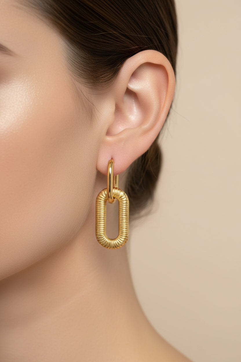 Close-up of chunky link drop earrings showcasing textured oval links and polished 18K PVD gold plating