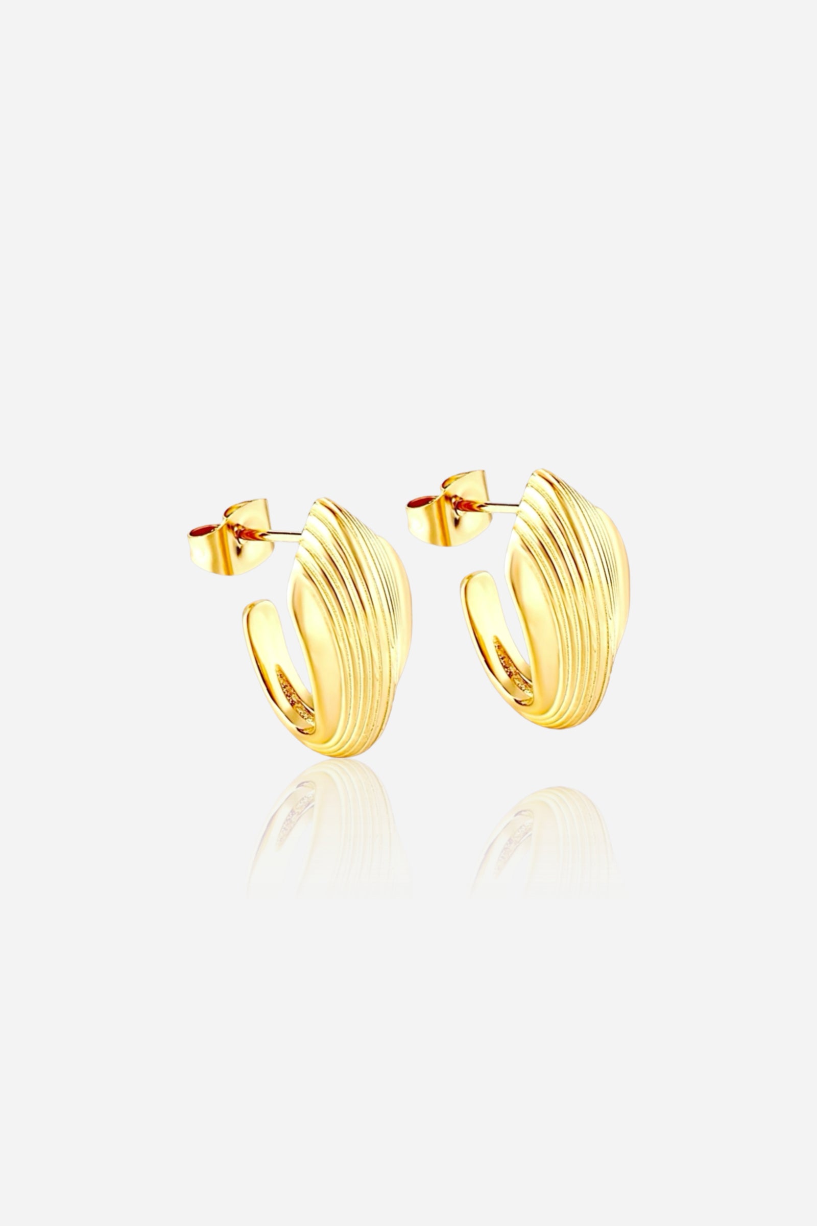 Close-up of textured oval half-hoop stud earrings made from stainless steel with a radiant PVD 18K gold plated finish, featuring elegant ribbed detailing and a modern sculpted silhouette – GLISTIA.