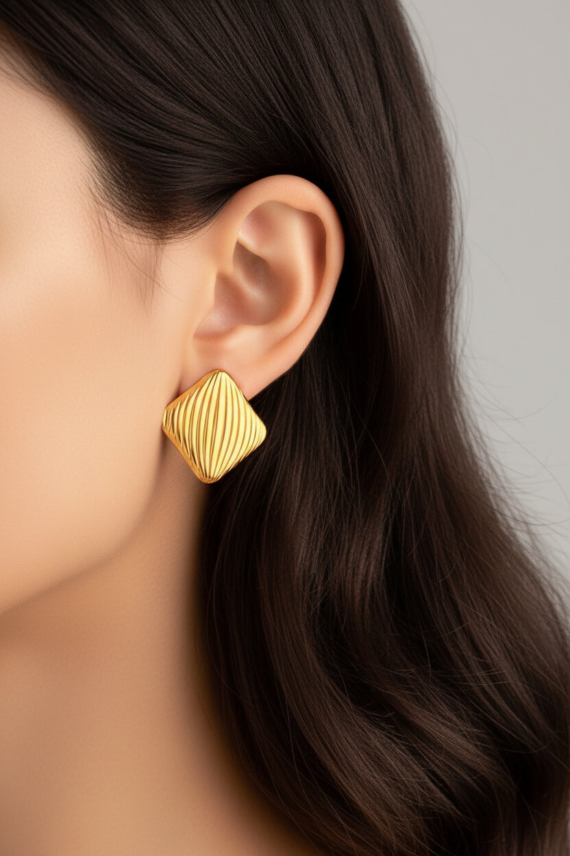 Textured square stud earrings worn on ear, showcasing modern wave pattern with 18K PVD gold plated finish