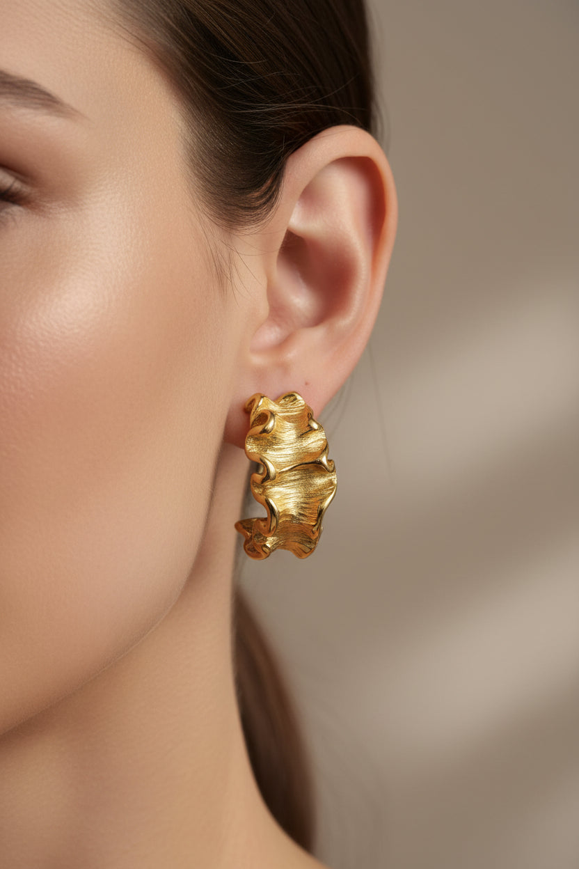Textured wave C-hoop earrings crafted from stainless steel with 18K PVD gold plating, featuring sculptural ruffled edges and a bold modern design