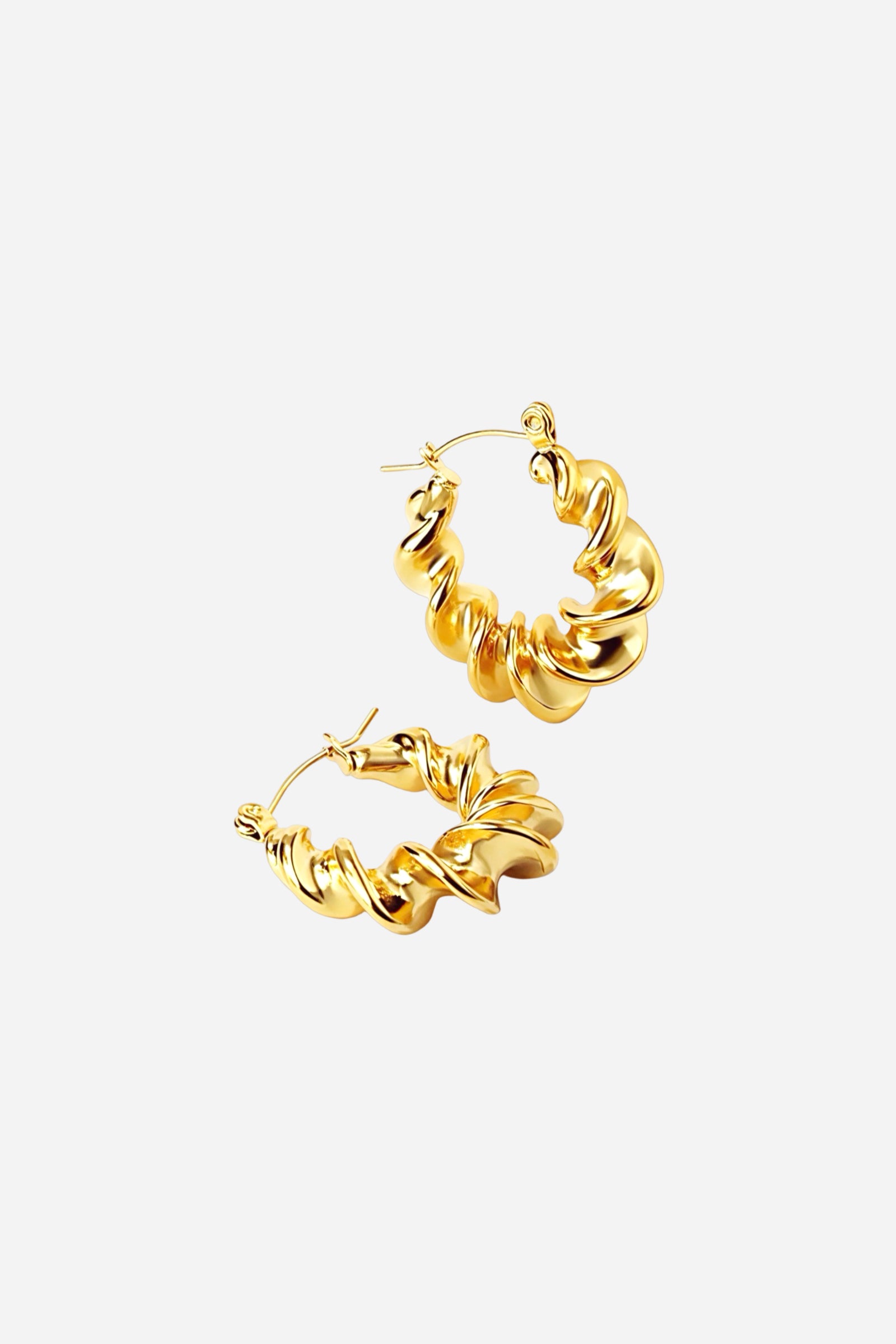 Angled view of twist design hoop earrings in 18K gold plated stainless steel with bold spiral silhouette and reflective finish – GLISTIA jewellery