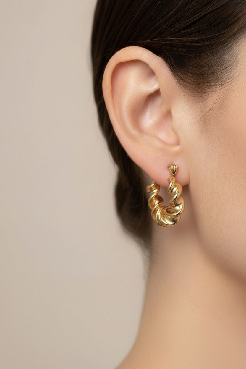 Twist design hoop earrings crafted from stainless steel with 18K PVD gold plating, featuring a bold wavy twisted texture and polished finish