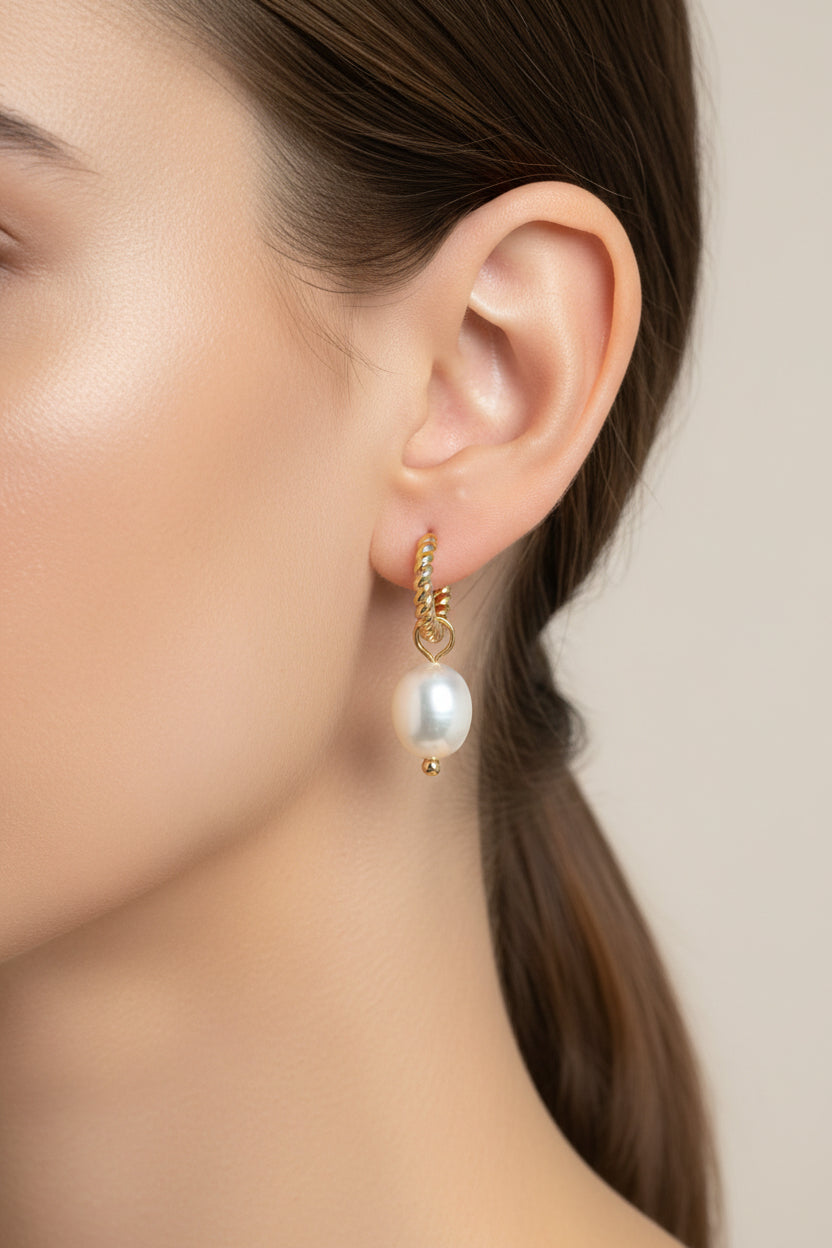 Close-up of twisted hoop earrings with pearl drop in 18K PVD gold plated stainless steel, showcasing textured hoop and elegant pearl charm